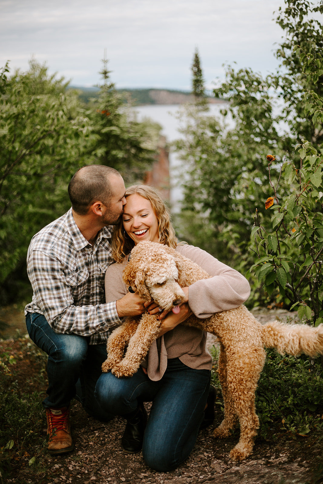 Couple hugging their Goldendoodle dog at the North Shore in Minnesota engagement session