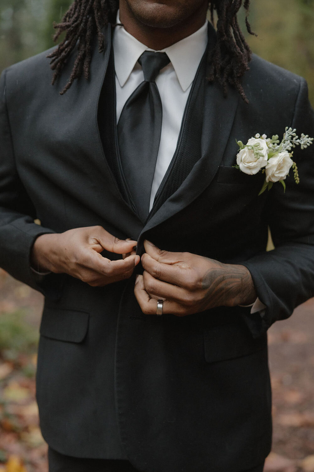 Groom fixing his suit button