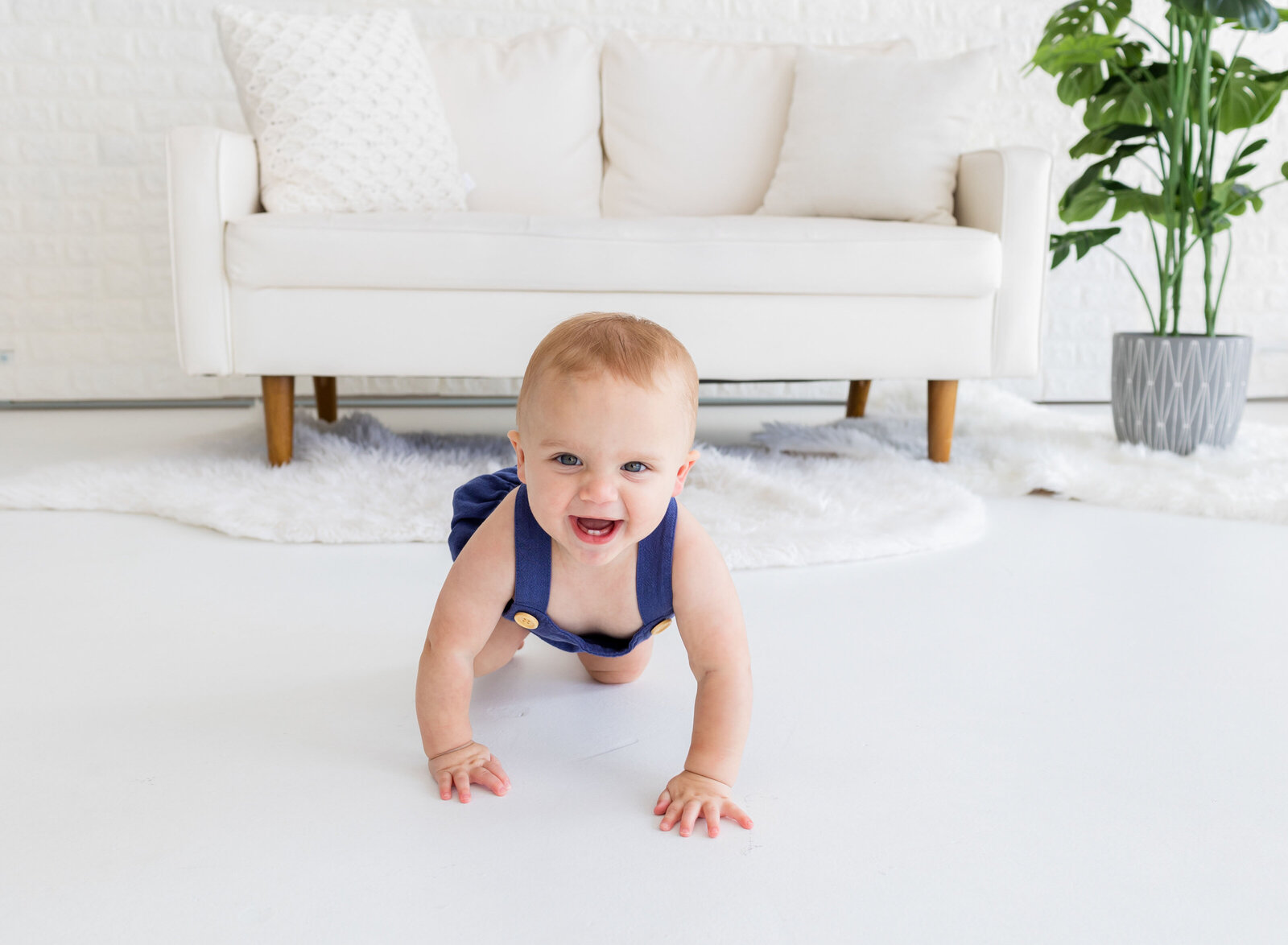 one year old boy smiling and crawling