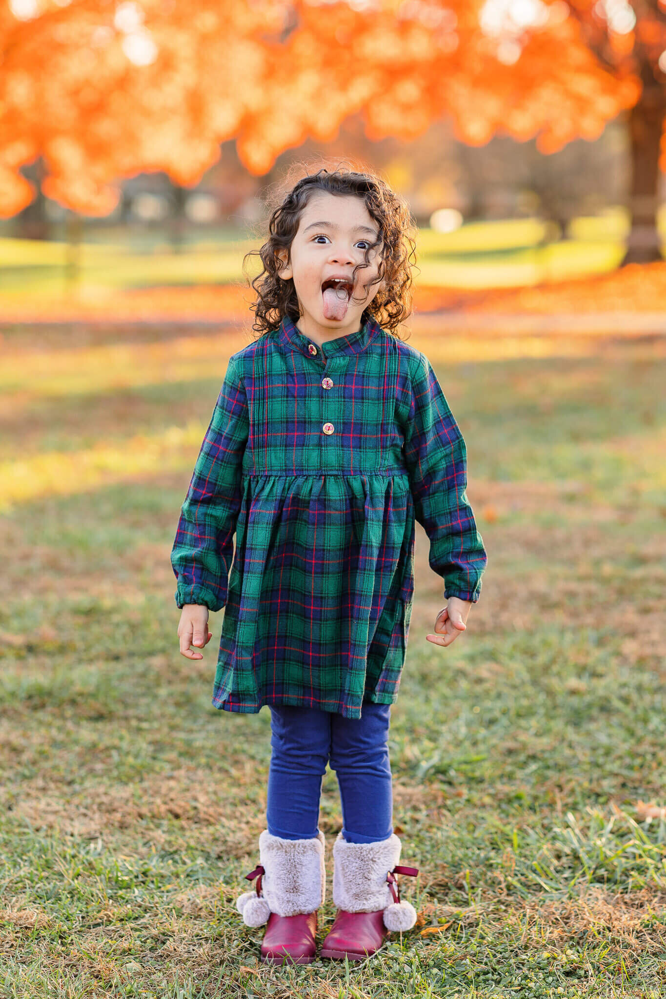A little girl standing at a NOVA park and sticking her tongue out