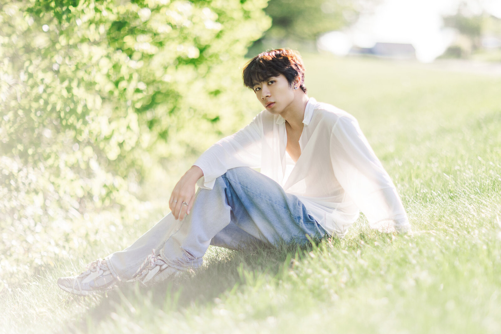 male sitting on grass with large bushes in albany ny