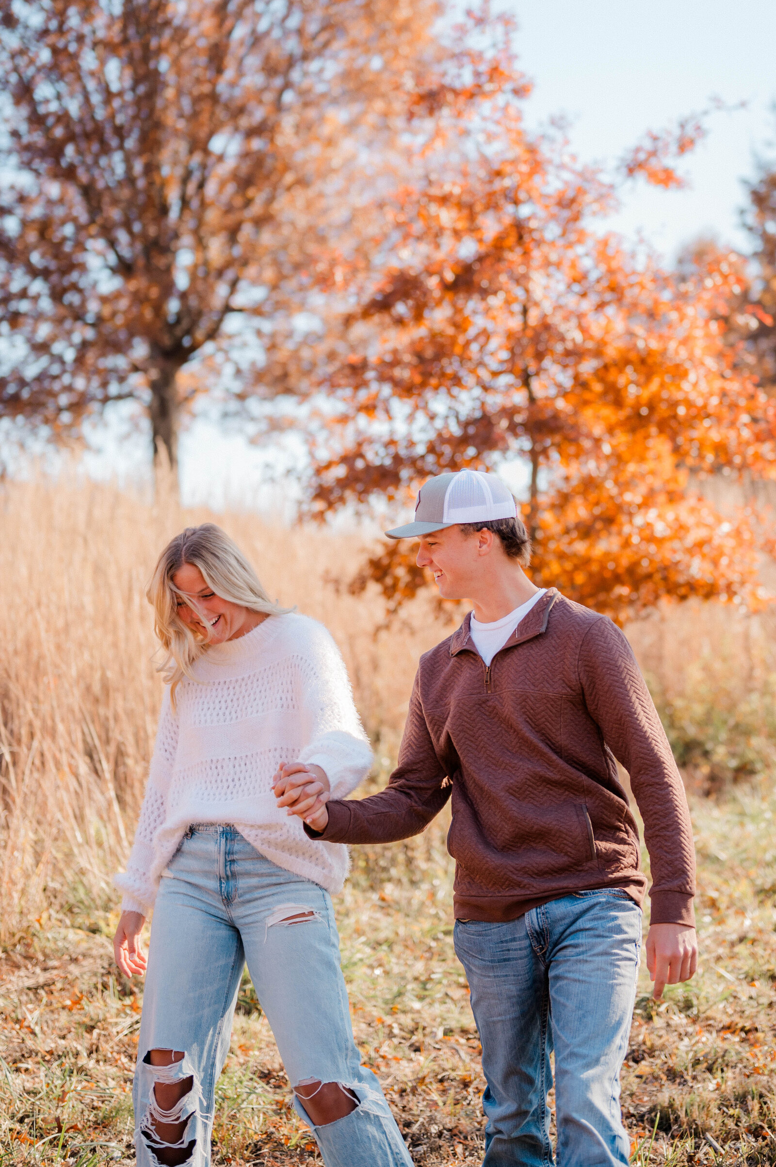 couple-walking-hand-in-hand-in-an-open-field-during-autumn