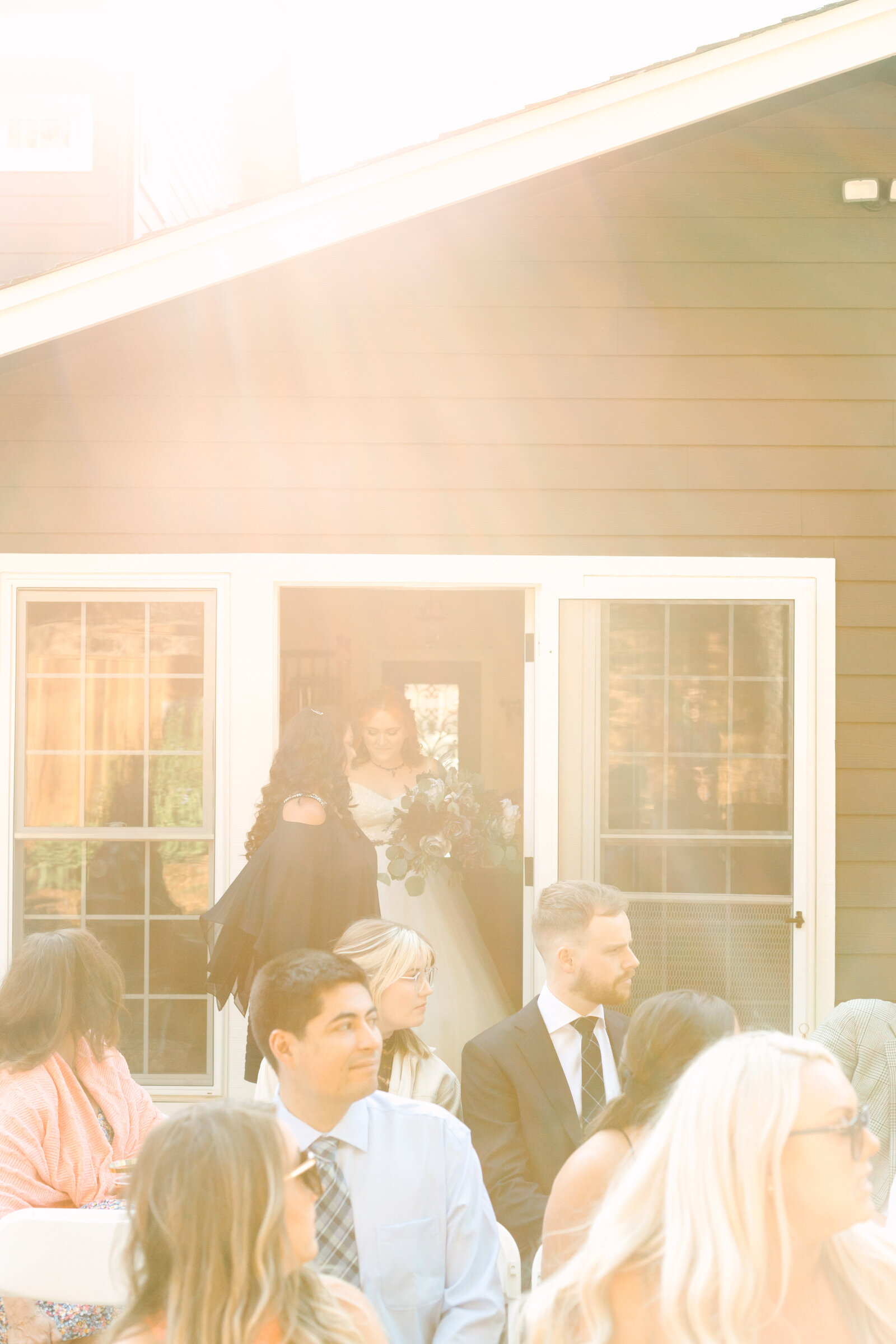 A bride enters her wedding ceremony on a sunny day.