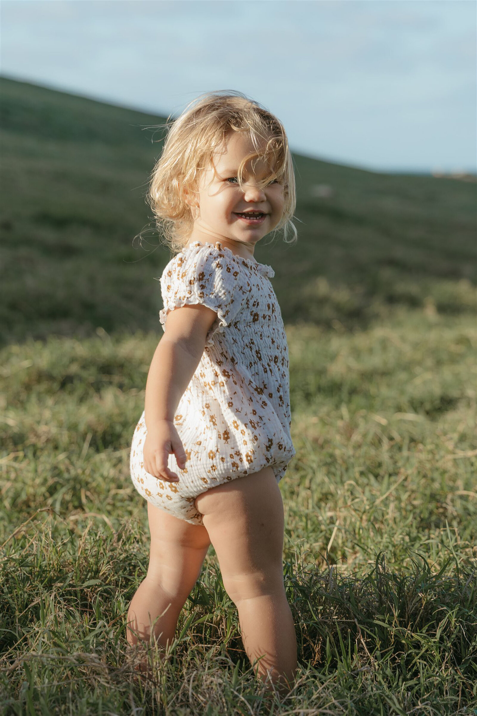 Children playing naturally during a styled Maui family photography session, ocean and sunset backdrop.
