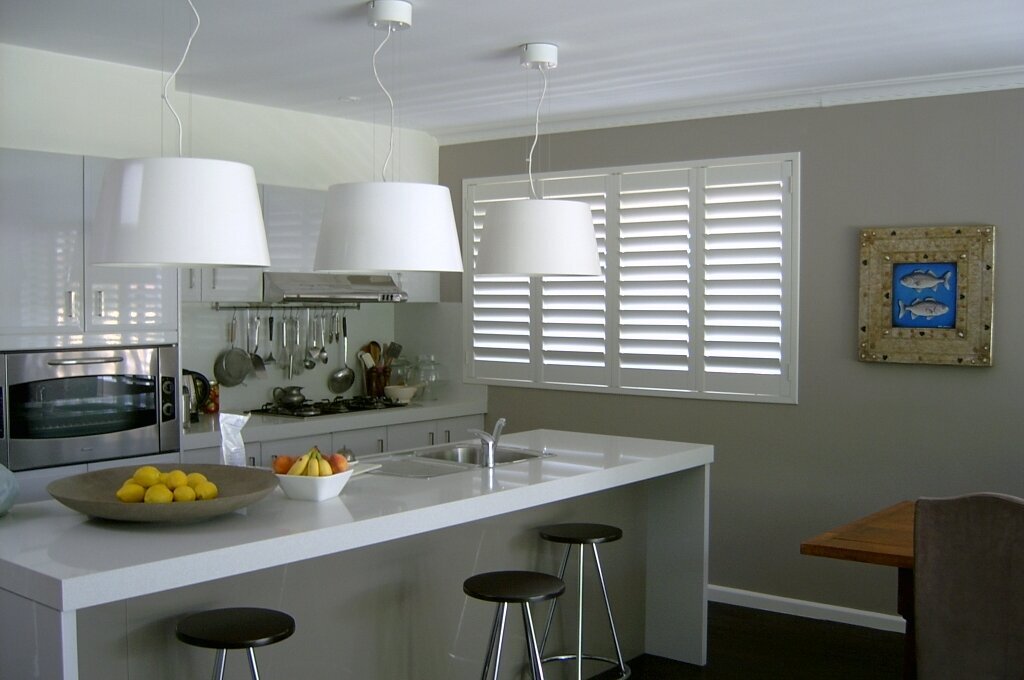 Sleek kitchen design with a custom glass splashback and energy-efficient windows, ideal for home upgrades.