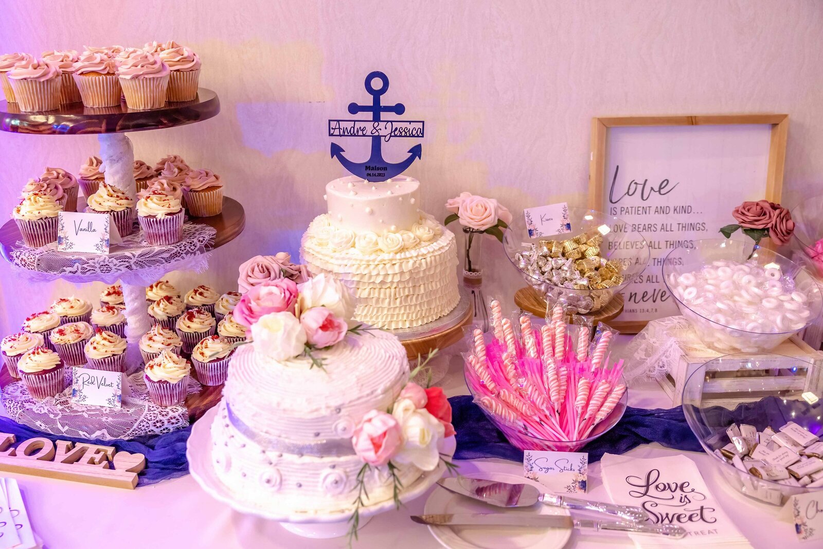 A nautical-themed dessert table featuring tiered wedding cakes, cupcakes, and decorative anchors, captured at a Carolina Beach, NC wedding, blending creative details with coastal charm.