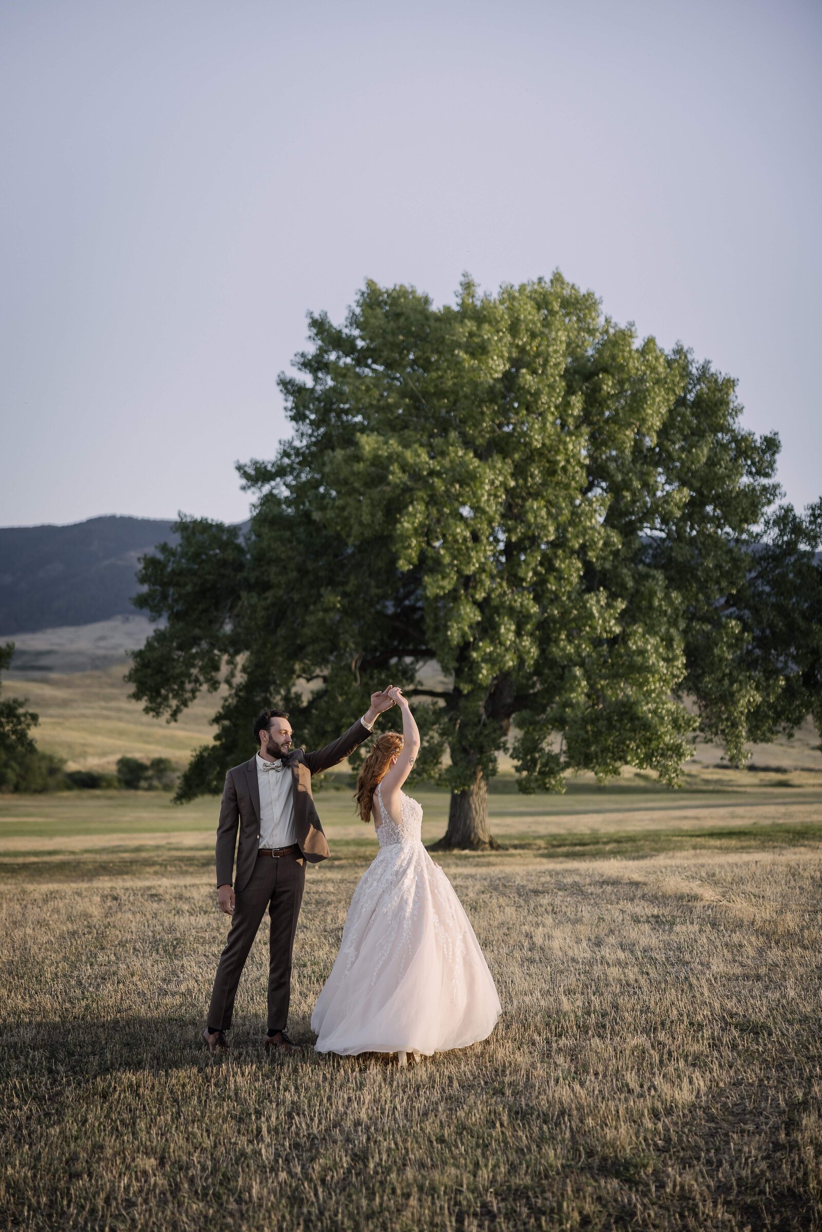 groom twirling bride at golden hour