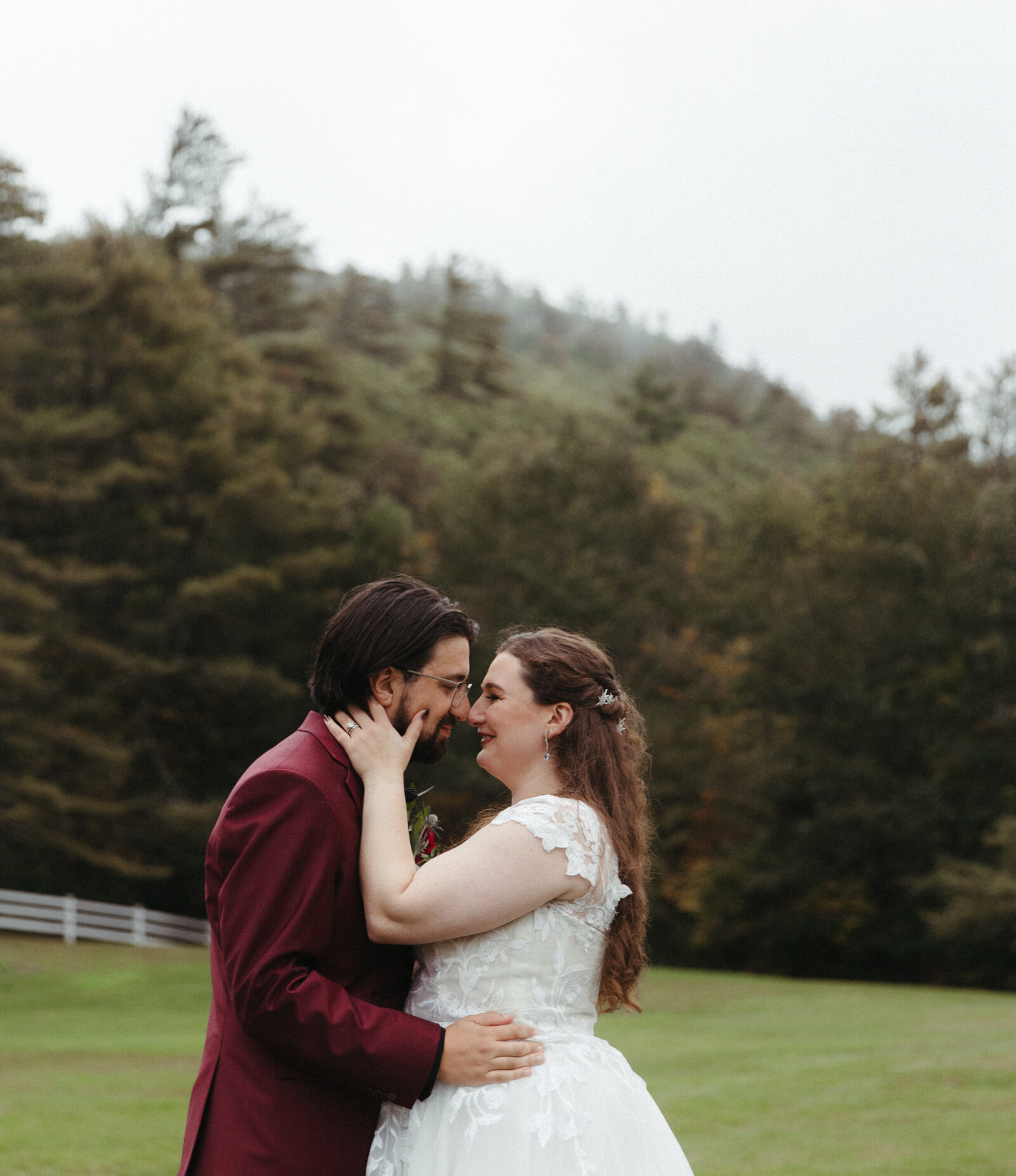 New England couple  kissing in a field