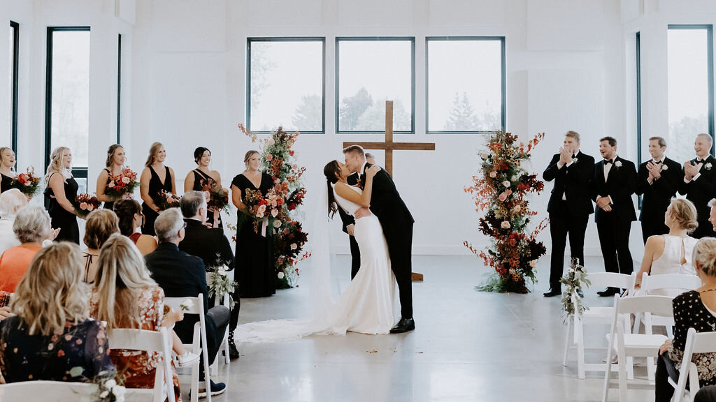 bride-groom-ceremony-kiss-cross-backdrop