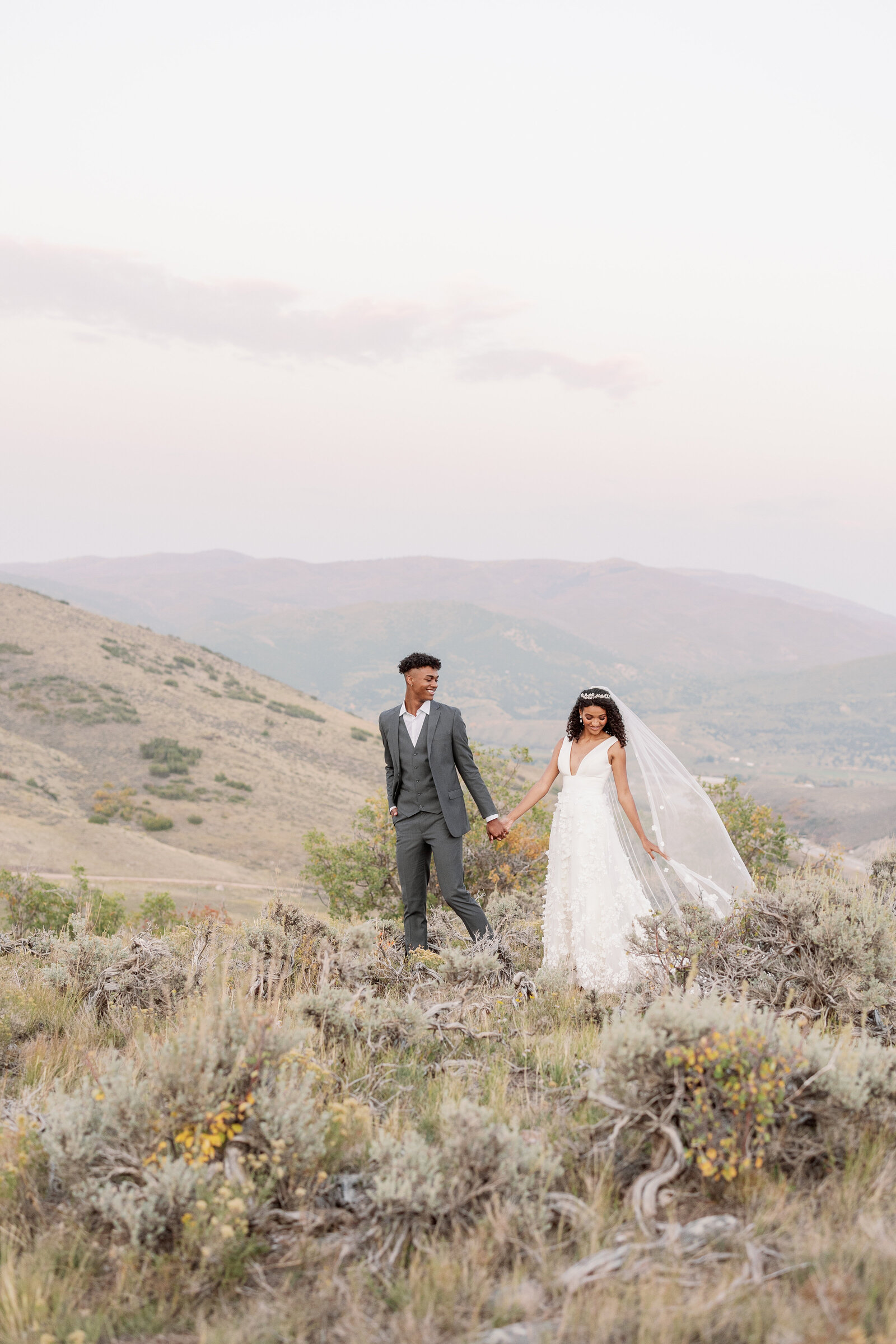 A couple walking in a field in the mountains together