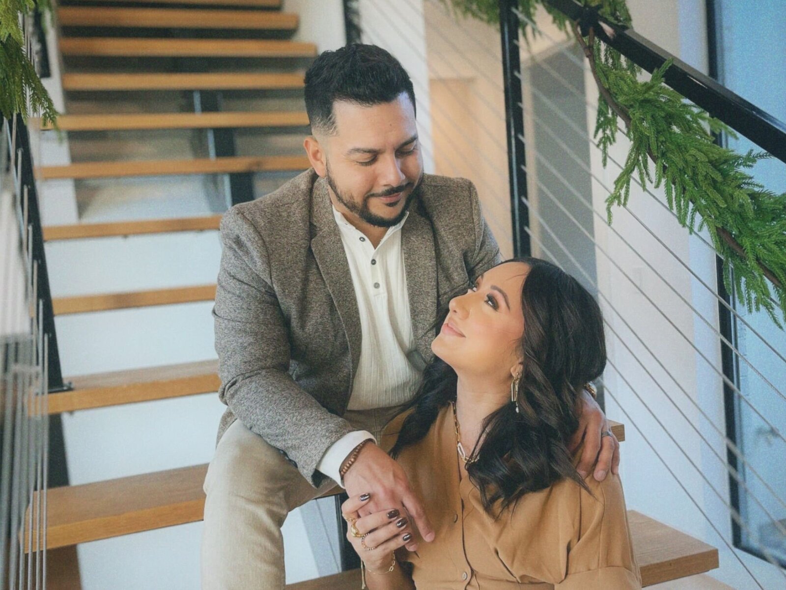 husband and wife interior design team pose in a renovated modern home
