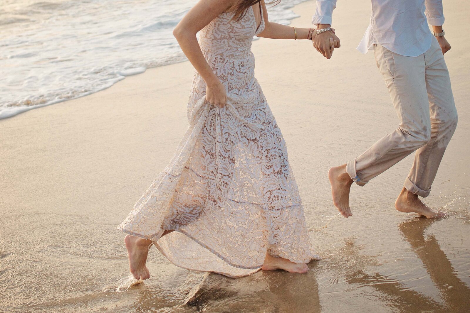 Engaged couple running on the beach boho dress branding photographer