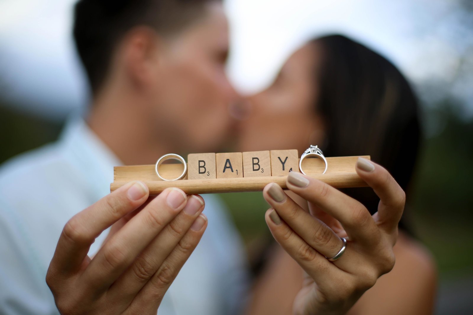 Couple holding scrabble tiles spelling "baby". Photo by Ross Photography, Trinidad, W.I..