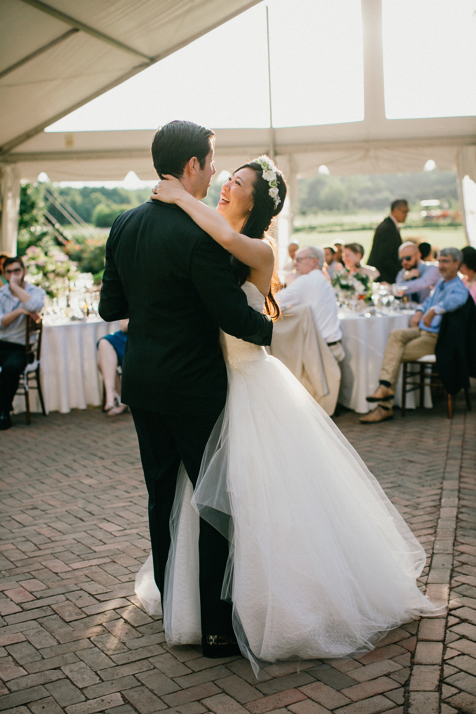 Bride and groom share their first dance together as husband and wife under the large event tent at Fernbrook Farm.