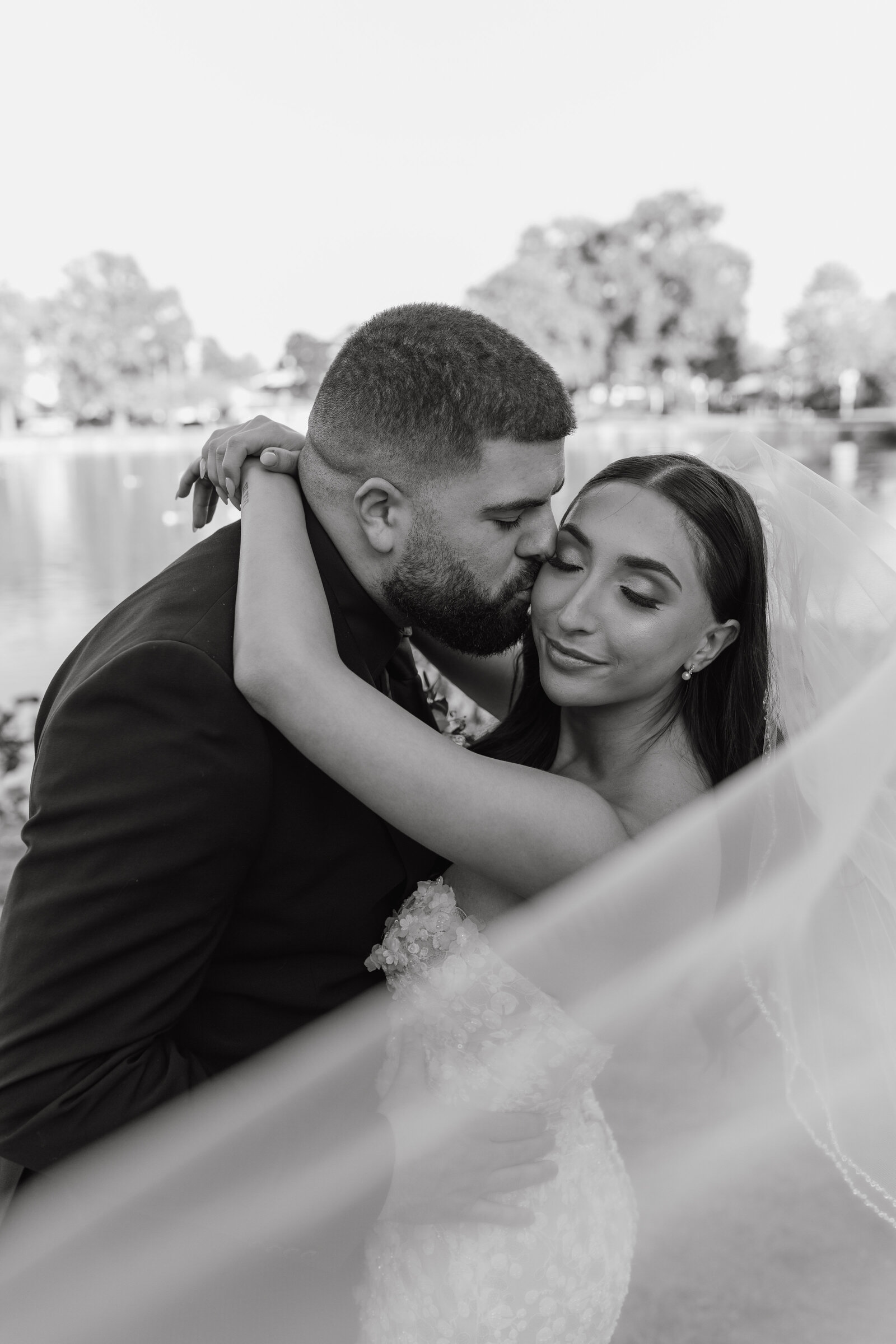 Black and white photo of a groom leaning down to kiss his bride after saying their "I dos" at a wedding venue in Long Island, NY | Emma LeeAnn Photography
