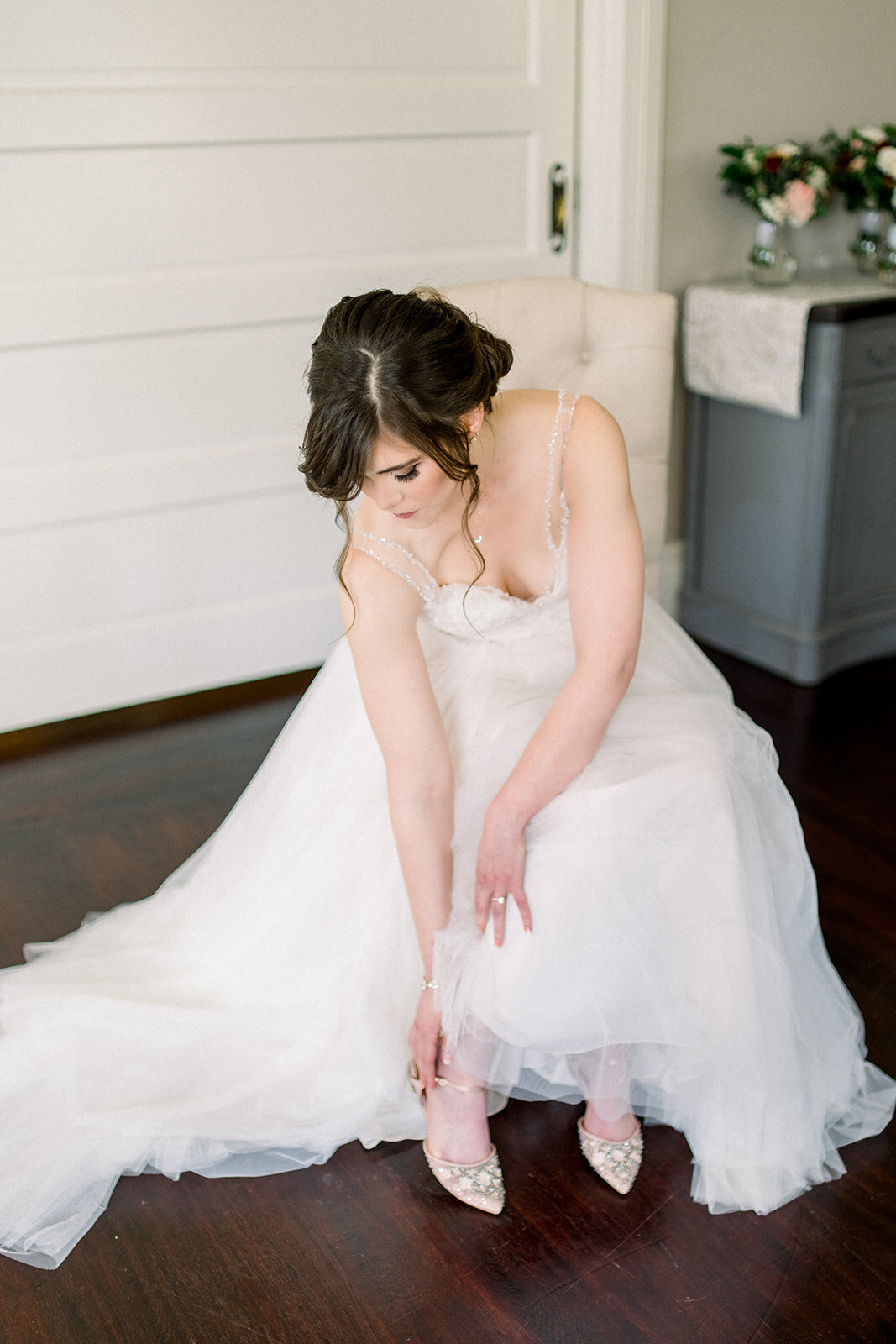 Bride putting on wedding shoes at Vizcaya in Sacramento, CA