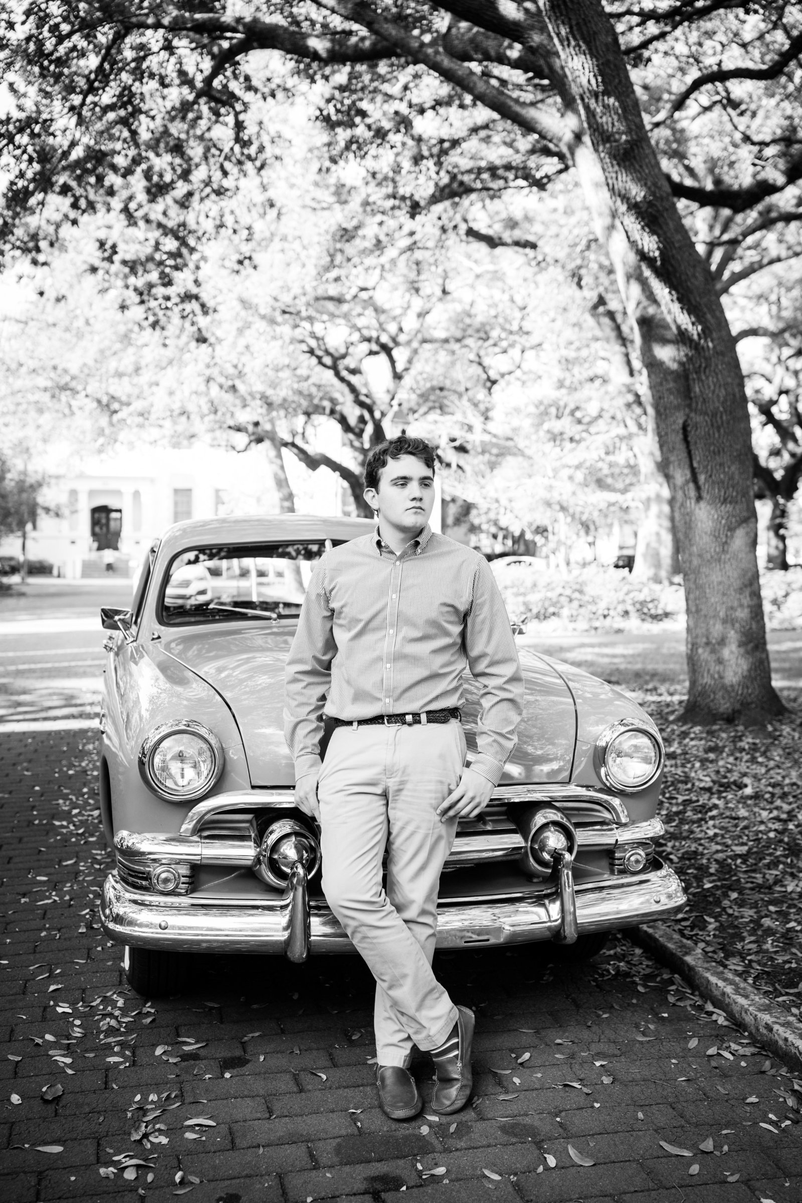 senior boy in front of a classic car in savannah