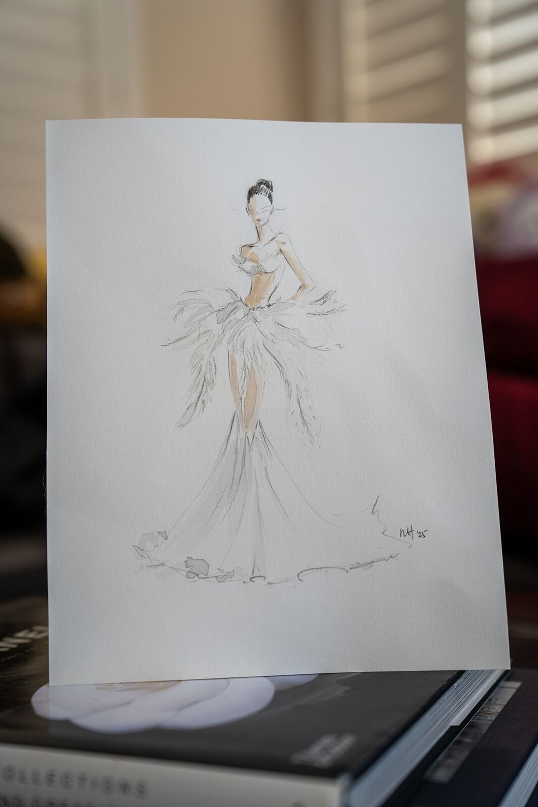Watercolor fashion illustration of a model in a white gown.