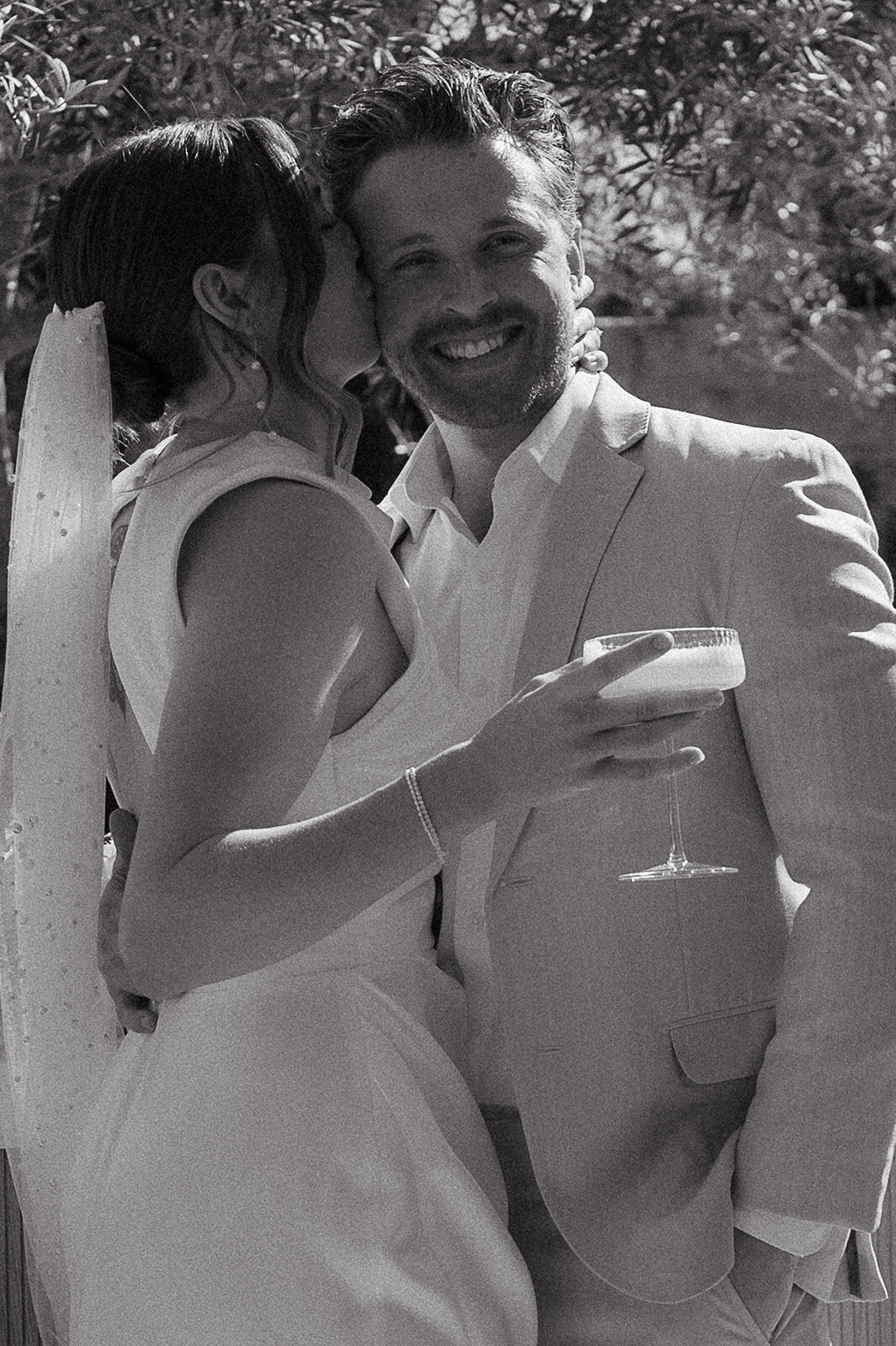 bride kissing groom on cheek during wedding day in orange county