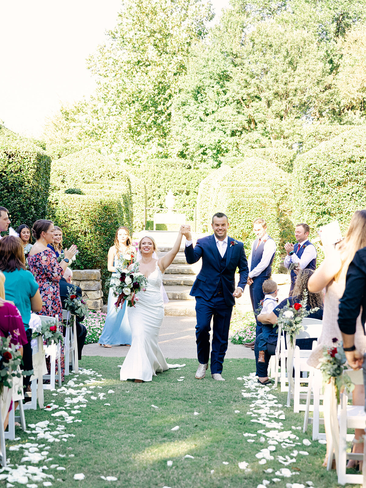 bride and groom holding hands and walking down the aisle at an outdoor wedding