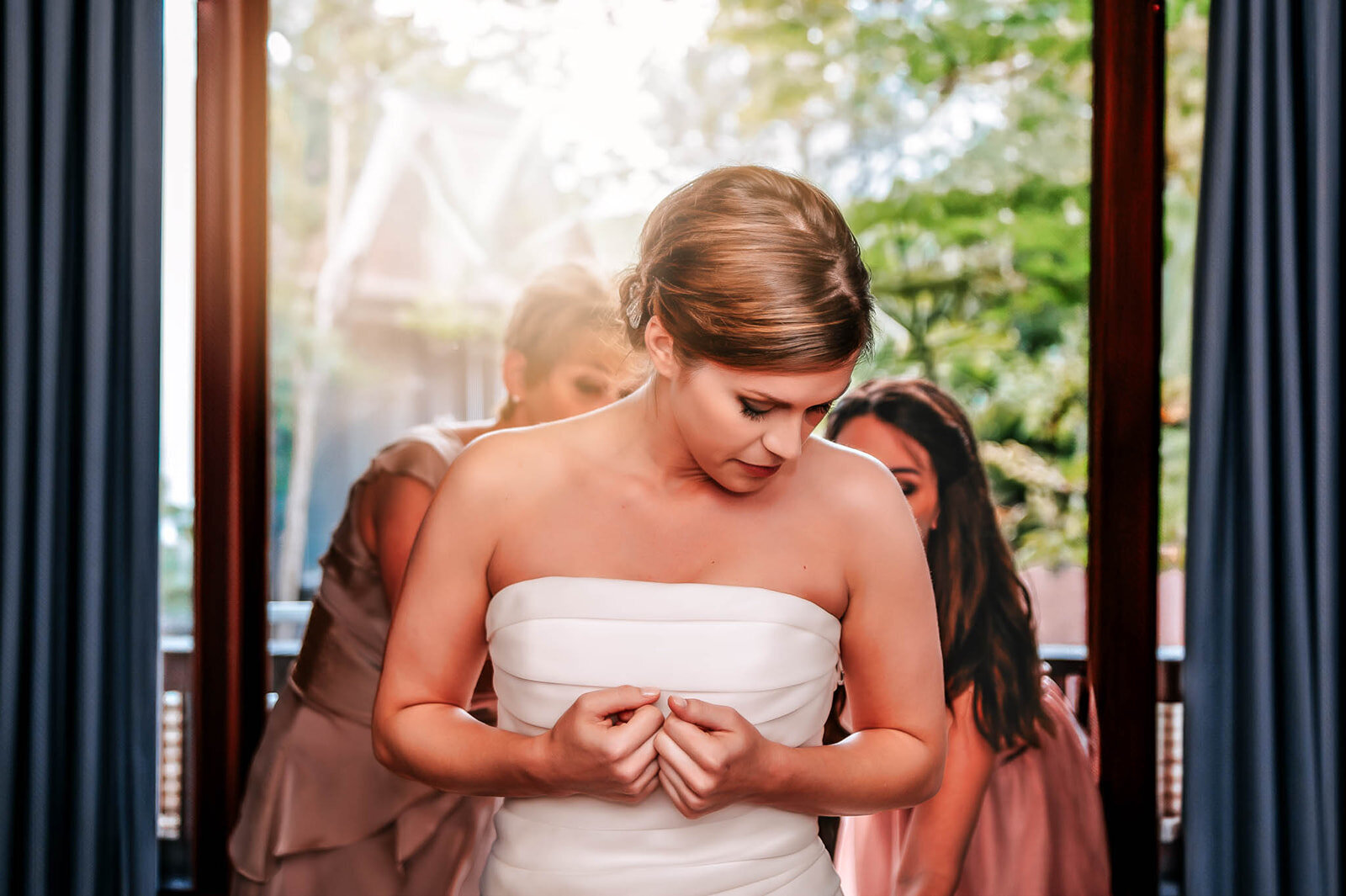 A bride adjusting her wedding gown before the ceremony, captured in an editorial-style portrait by CMH Studios