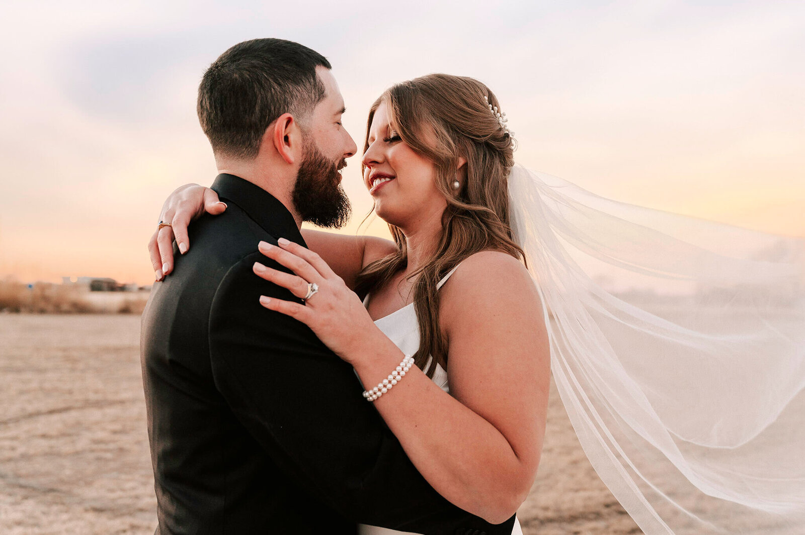 Bride and groom looking at eachother smiling about to kiss