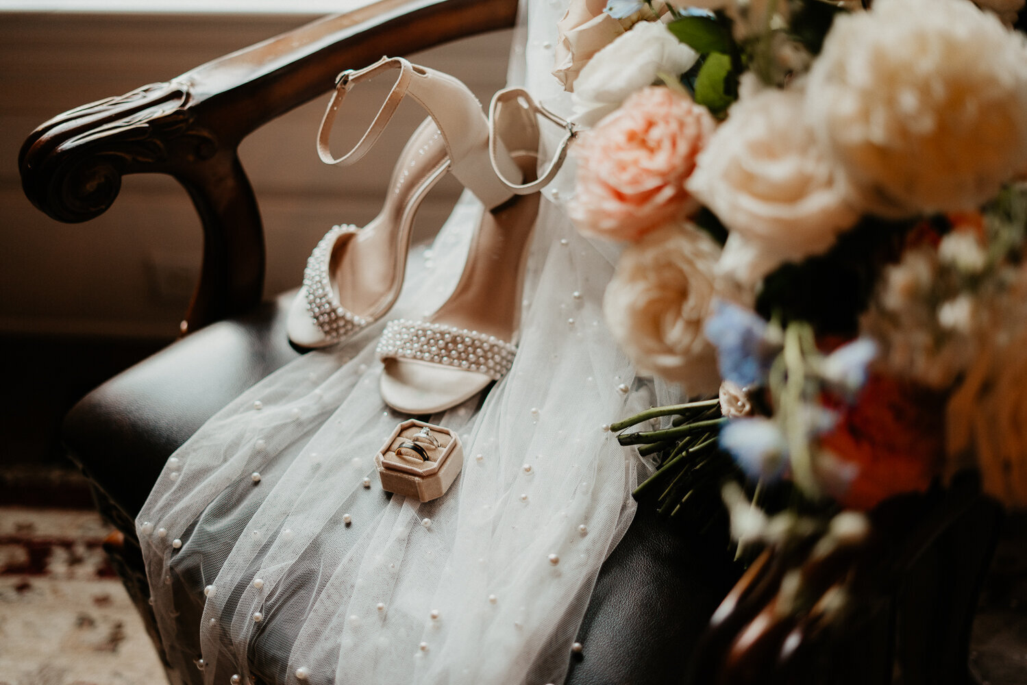 Bridal flatlay including shoes, rings and bouquet