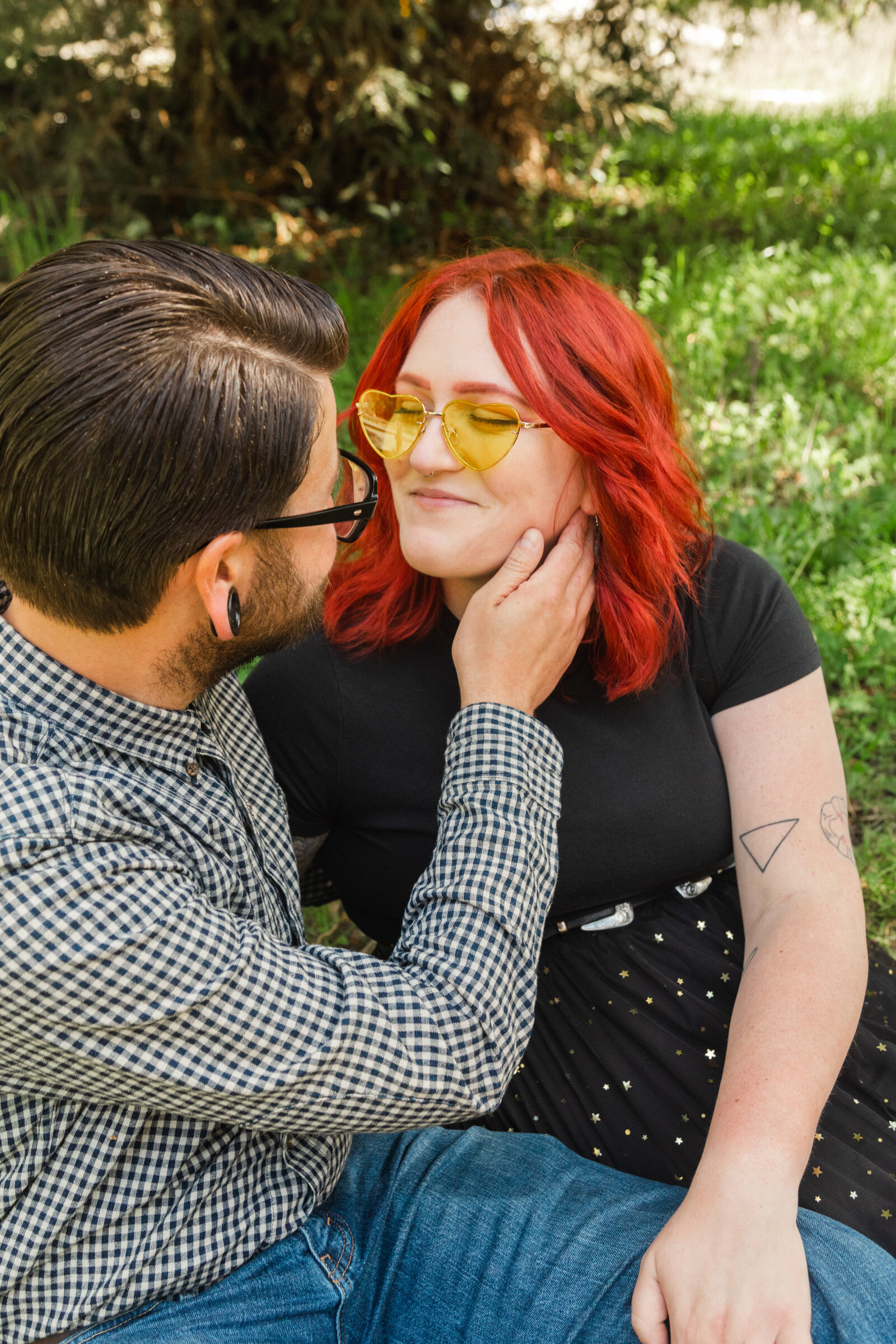 An tattooed engaged couple poses for photos in a redwood forest in Santa Cruz, Ca.