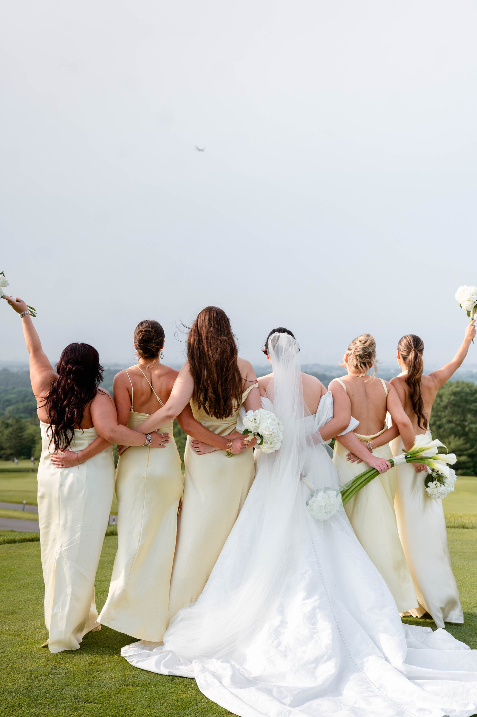 Bride with her bridesmaids embracing together looking at the Skyline of Boston Massachusetts