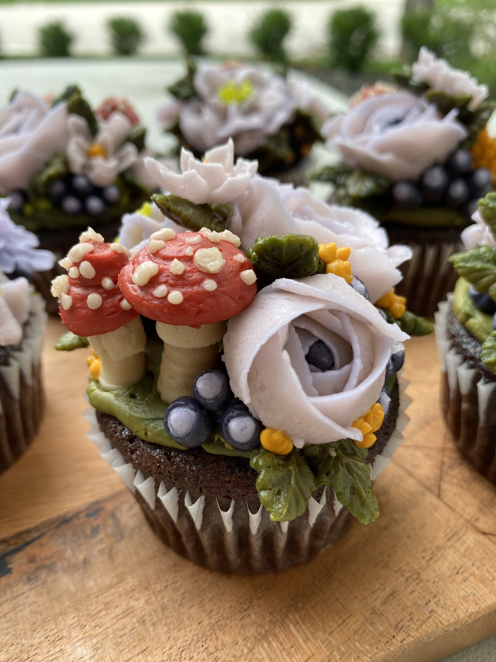 Cupcakes with hand piped flowers and mushrooms