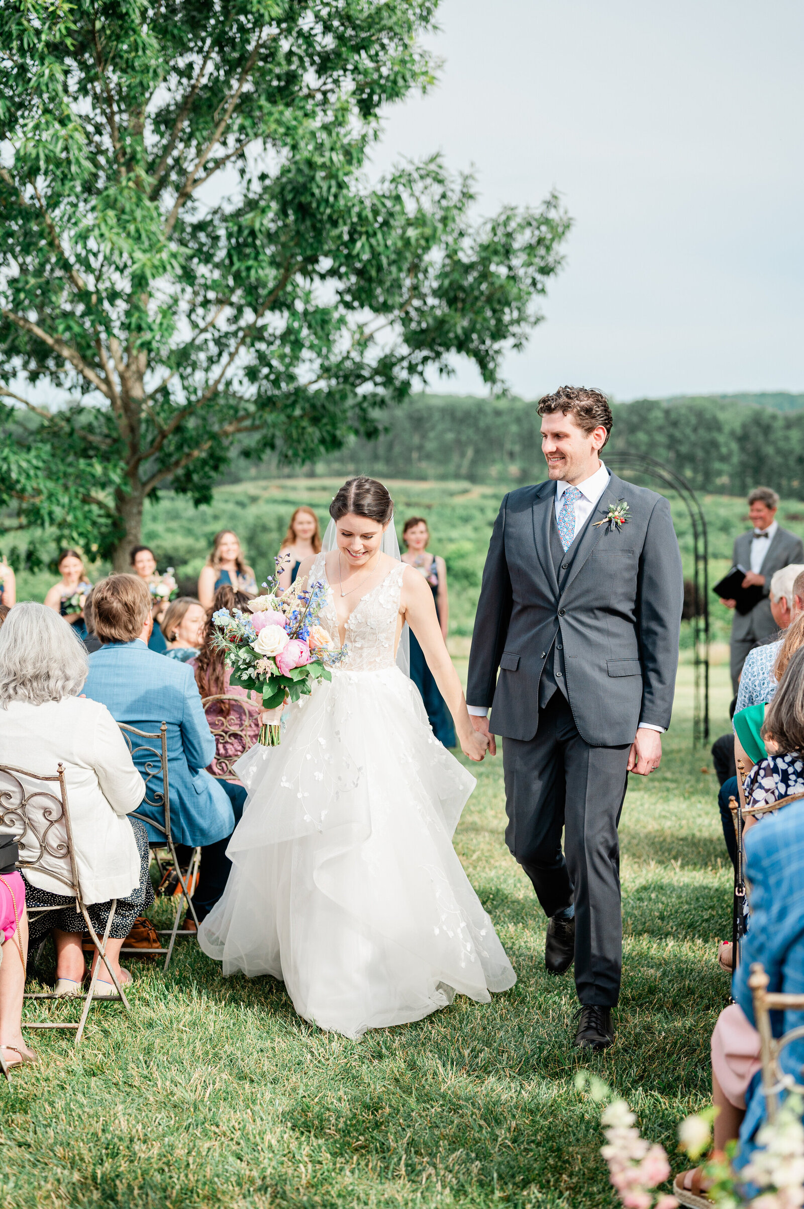 A wedding couple holding hands and walking back up the aisle after their wedding ceremony