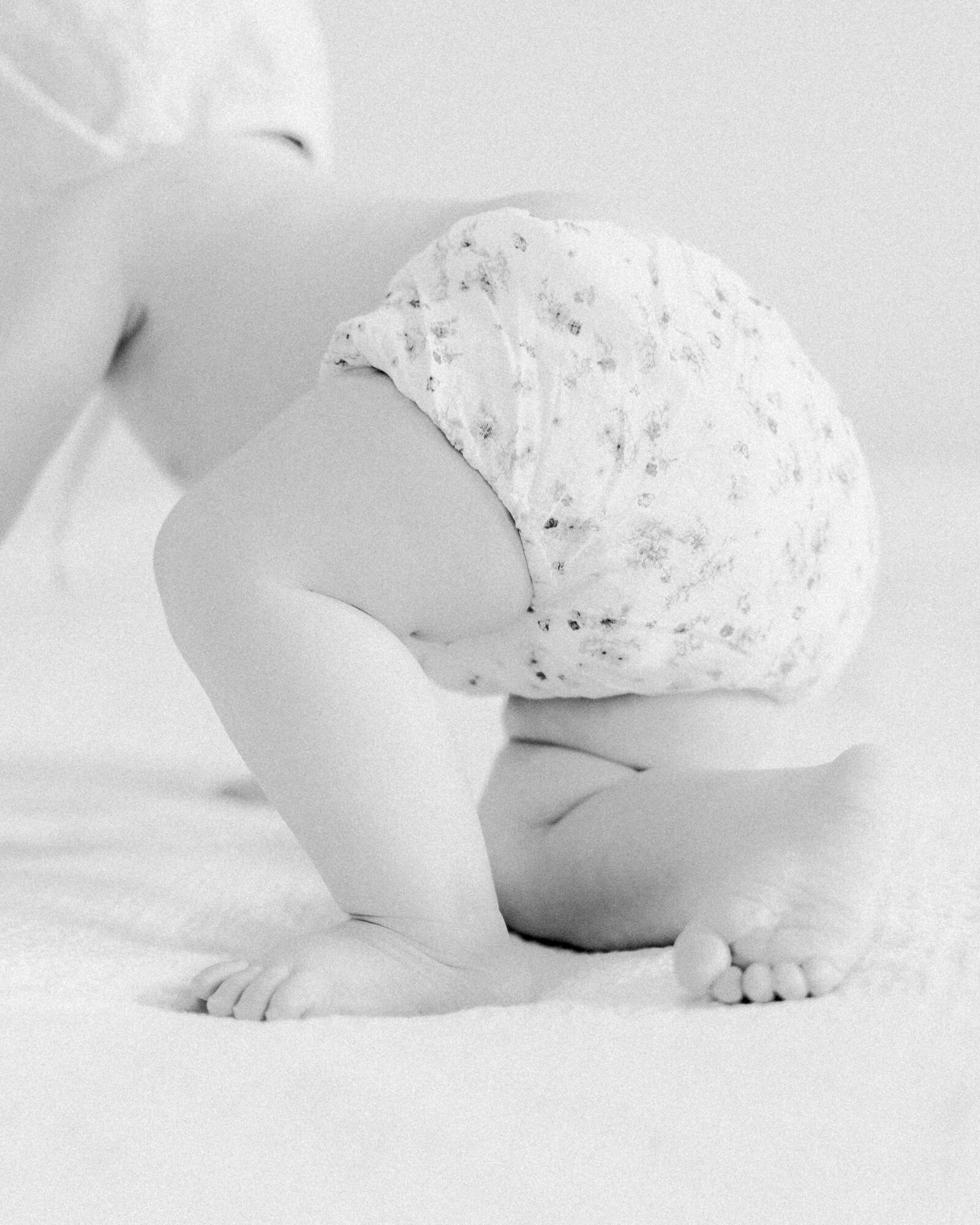 Closeup detail of baby in floral bloomers crawling away by NH newborn photographer Fieldstone Studio.