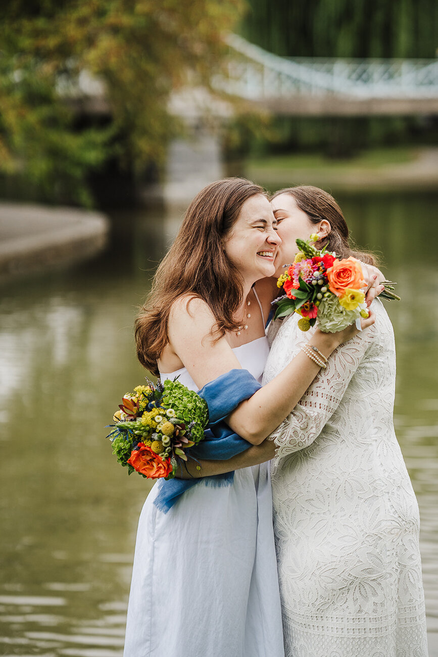 brides smile and hug in garden after boston elopement