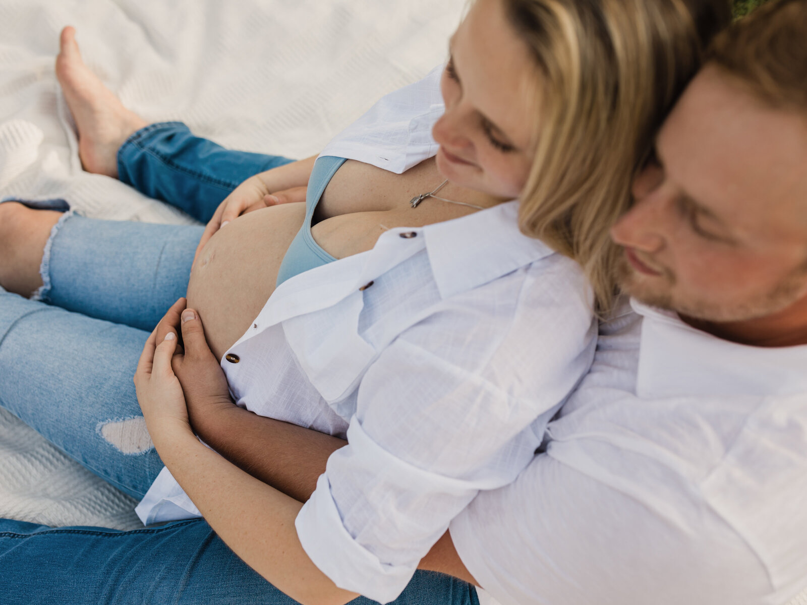 mother and father holding pregnant belly for maternity photoshoot