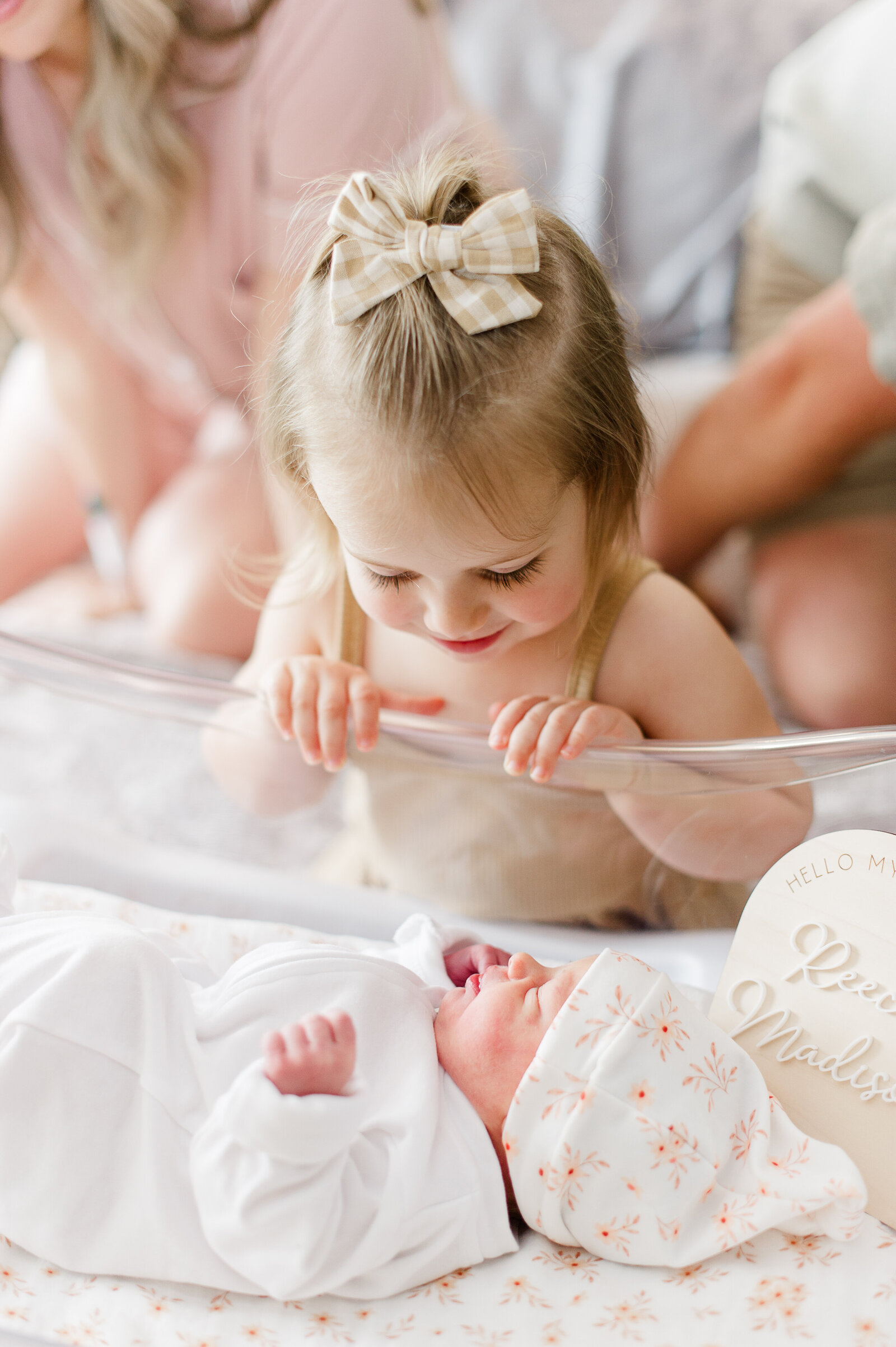 Older sister admires her brand new baby sister at the hospital during their Fresh 48 session