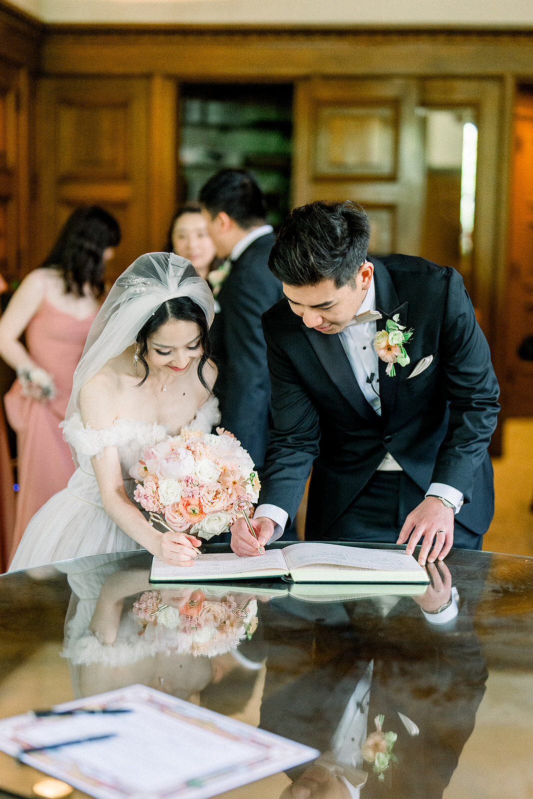 The bride and groom share an intimate moment signing their marriage license at Filoli, a luxurious wedding venue in Woodside, California.