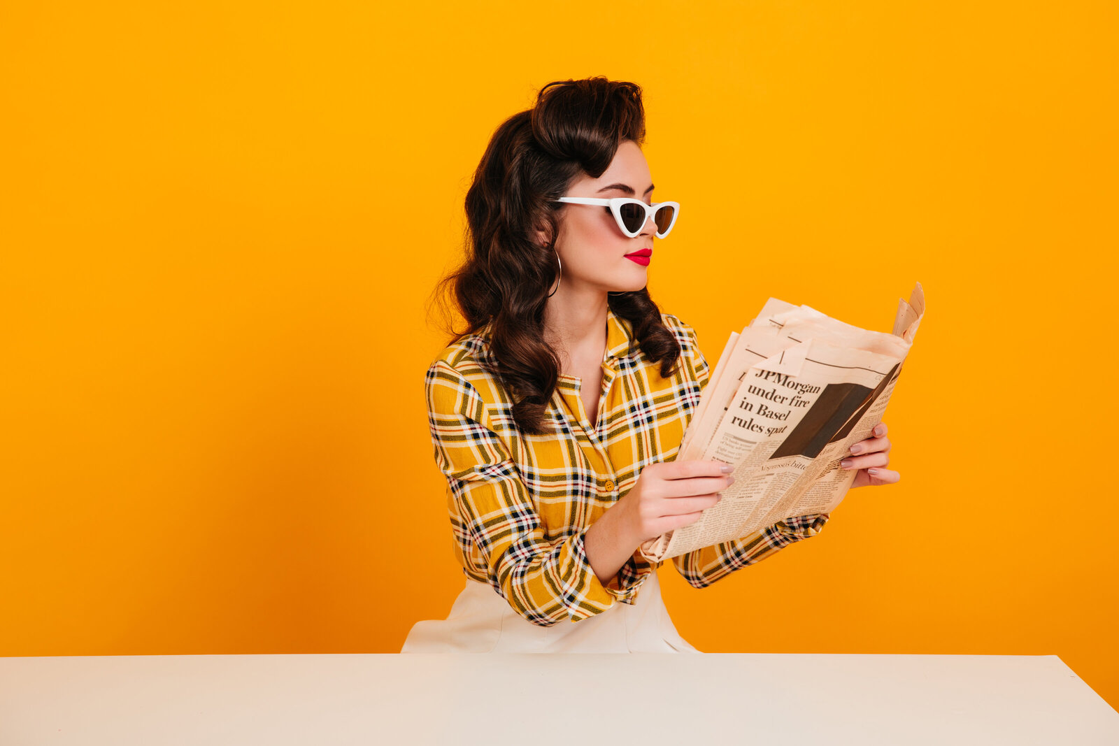elegant-young-woman-reading-newspaper-studio-shot-concentrated-pinup-girl-posing-yellow-background