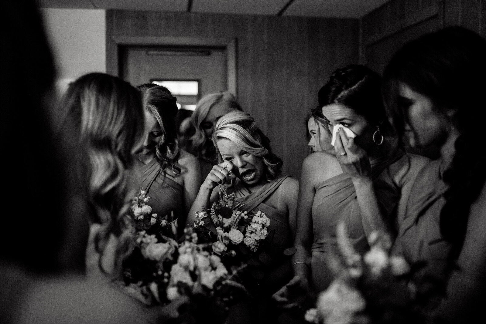 photo of the bridesmaids crying together as the bride givings a touching speech.