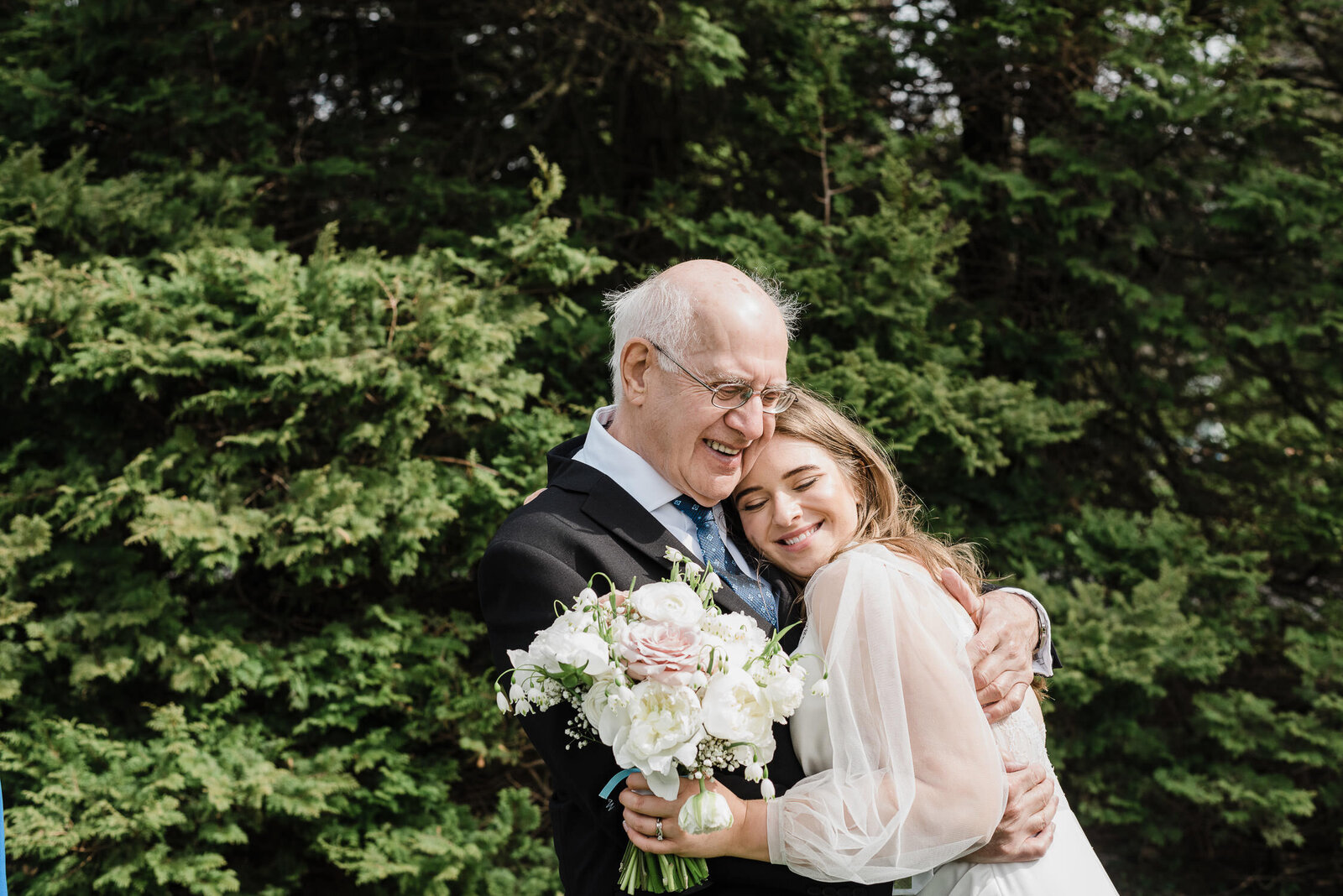 Intimate moment of bride hugging father at Nova Scotia wedding.