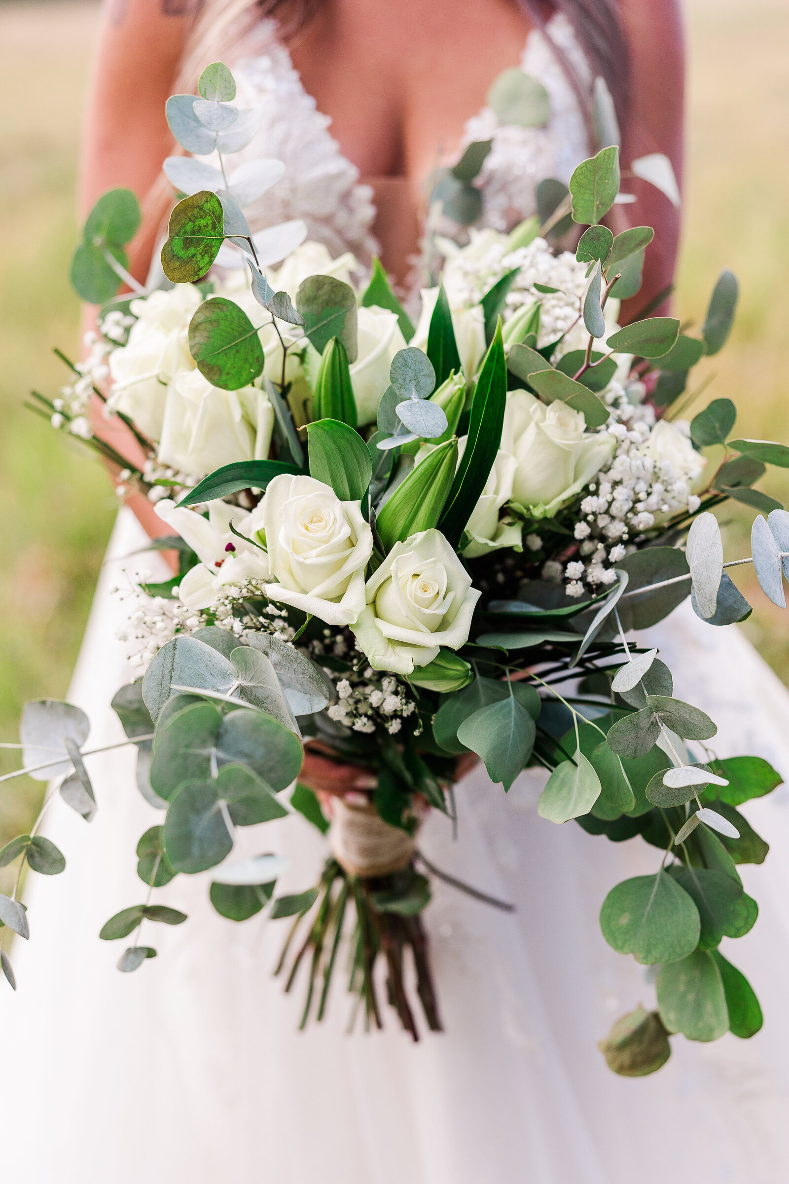 Bride's beautiful huge bouquet filled with white roses and eucalyptus greens in Arrowhead Colorado