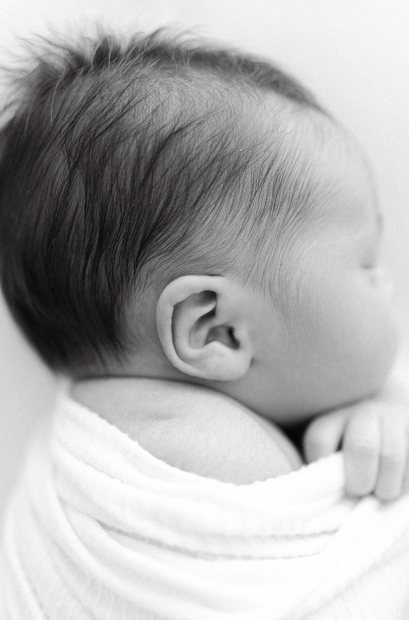 Black and white close-up of newborn baby boy wrapped in swaddle | Chelsea Nichole Photography North Dakota