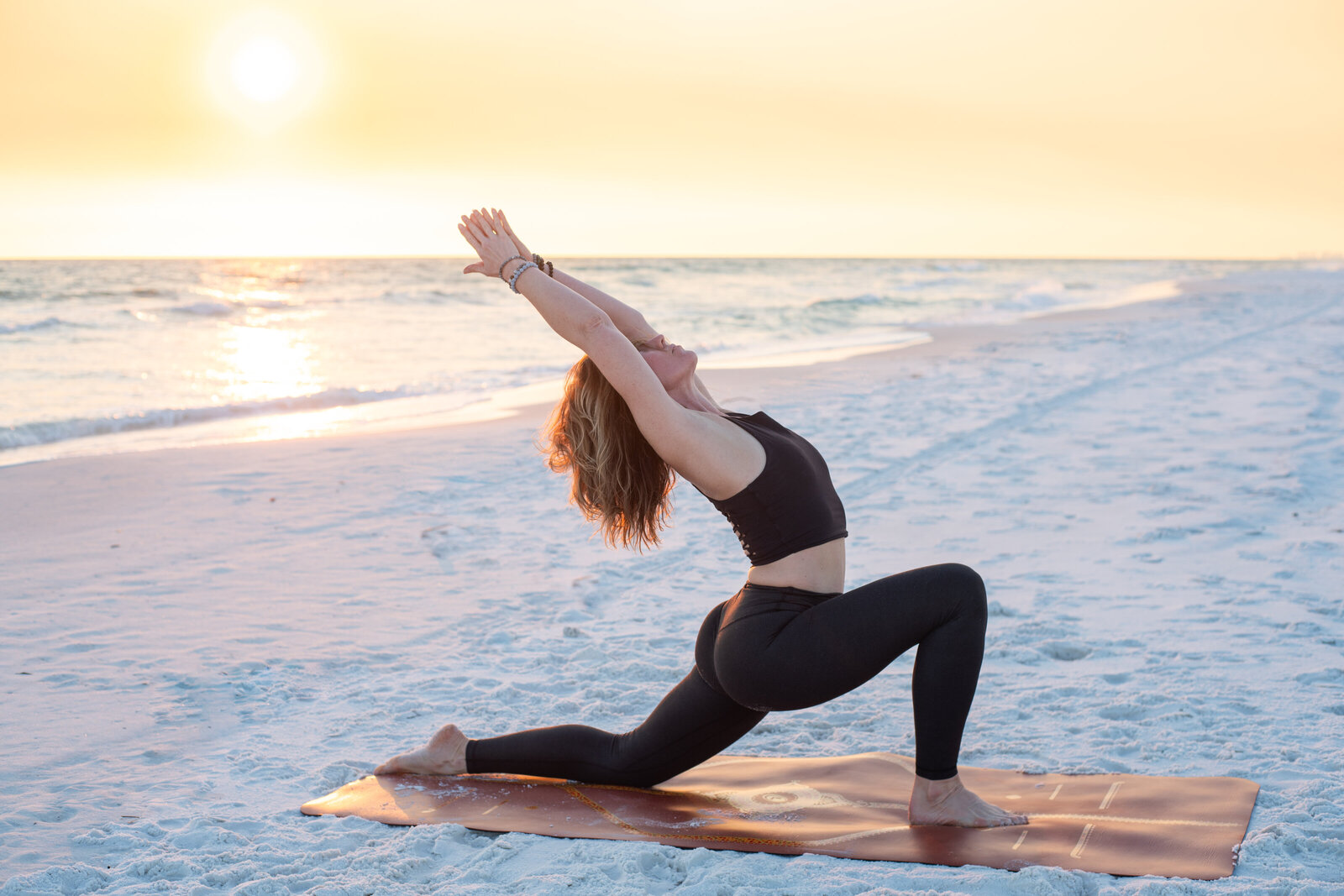 Stephanie in a low lunge on the beach 