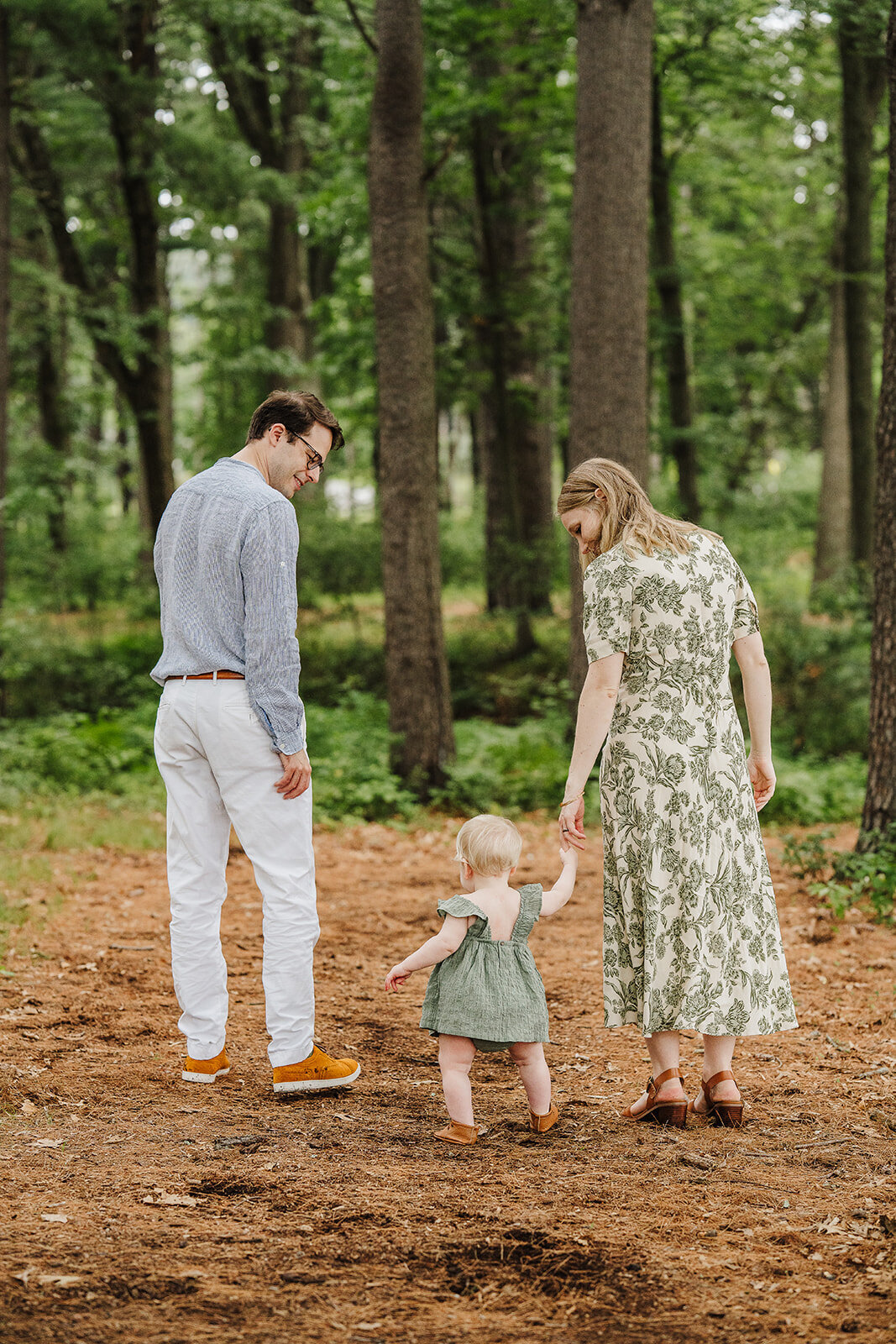 mom and dad walk with one year old in woods for boston family phtoos