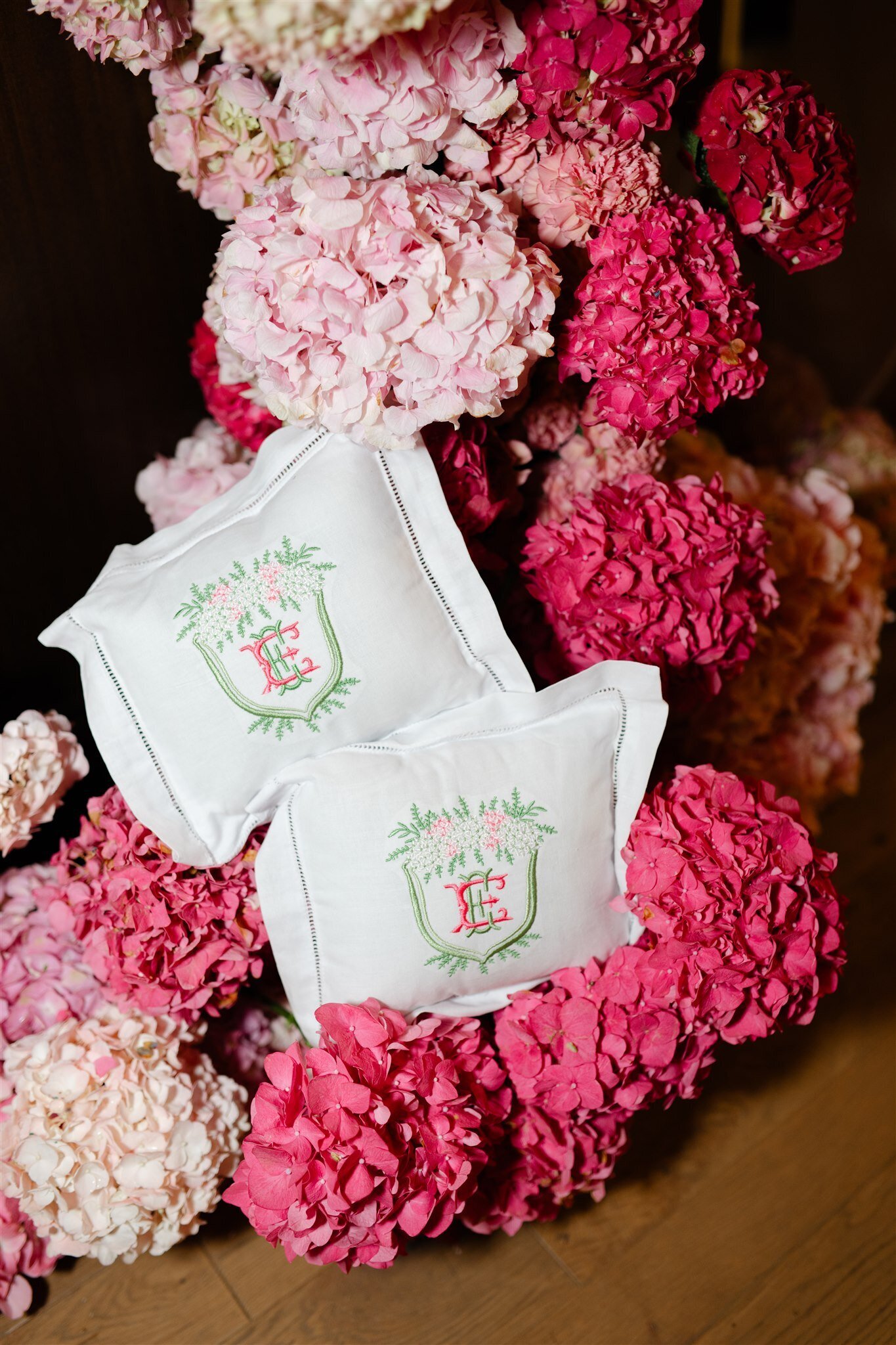 custom monogrammed ring bearer pillows sitting on a waterfall of pink hydrangeas
