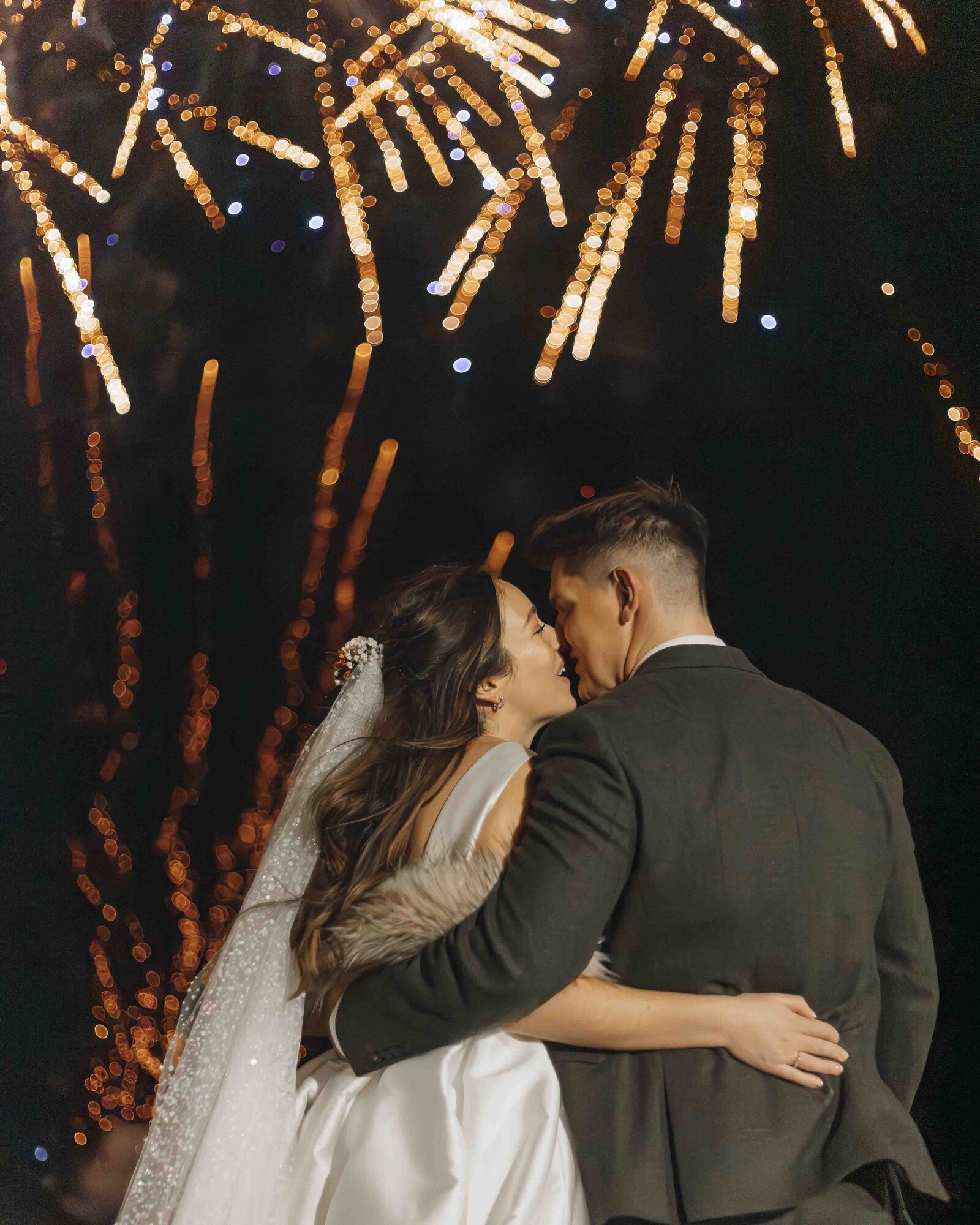 bride and groom kissing fireworks