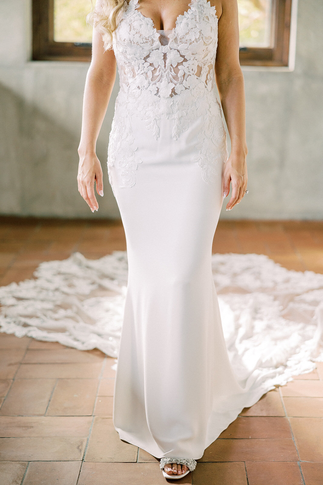 bride stands in sun room showing beading on her dress