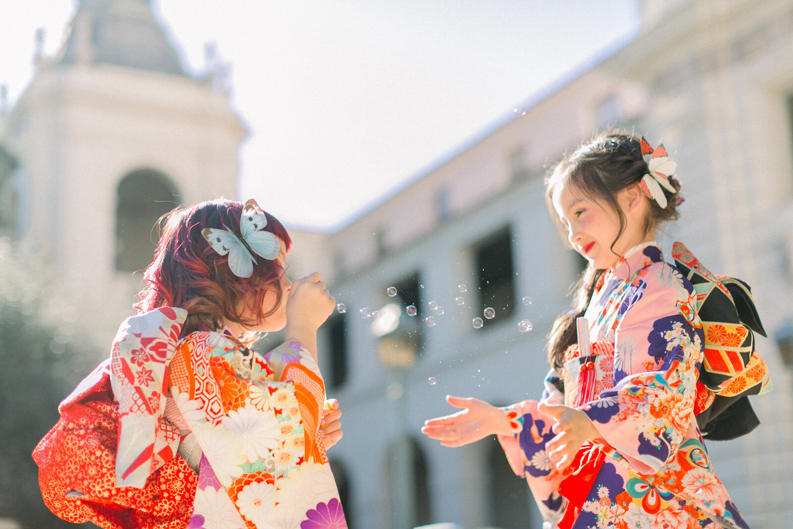 Two children in colorful kimono blowing and catching bubbles during Shichi-Go-San celebration at Pasadena City Hall | 七五三 パサデナ市庁舎 しゃぼん玉で遊ぶ兄妹