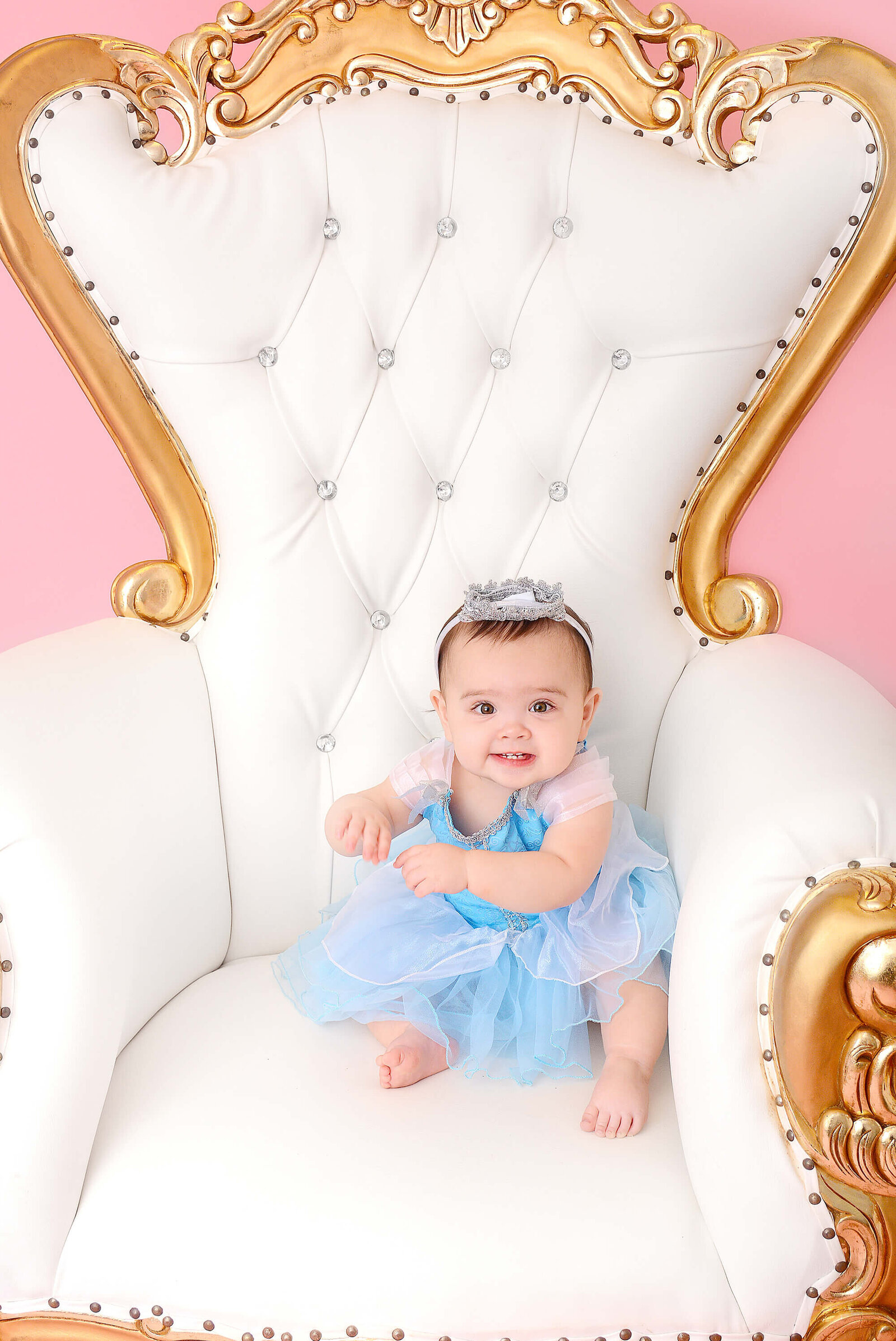girl sits in throne at her first birthday shoot in houston