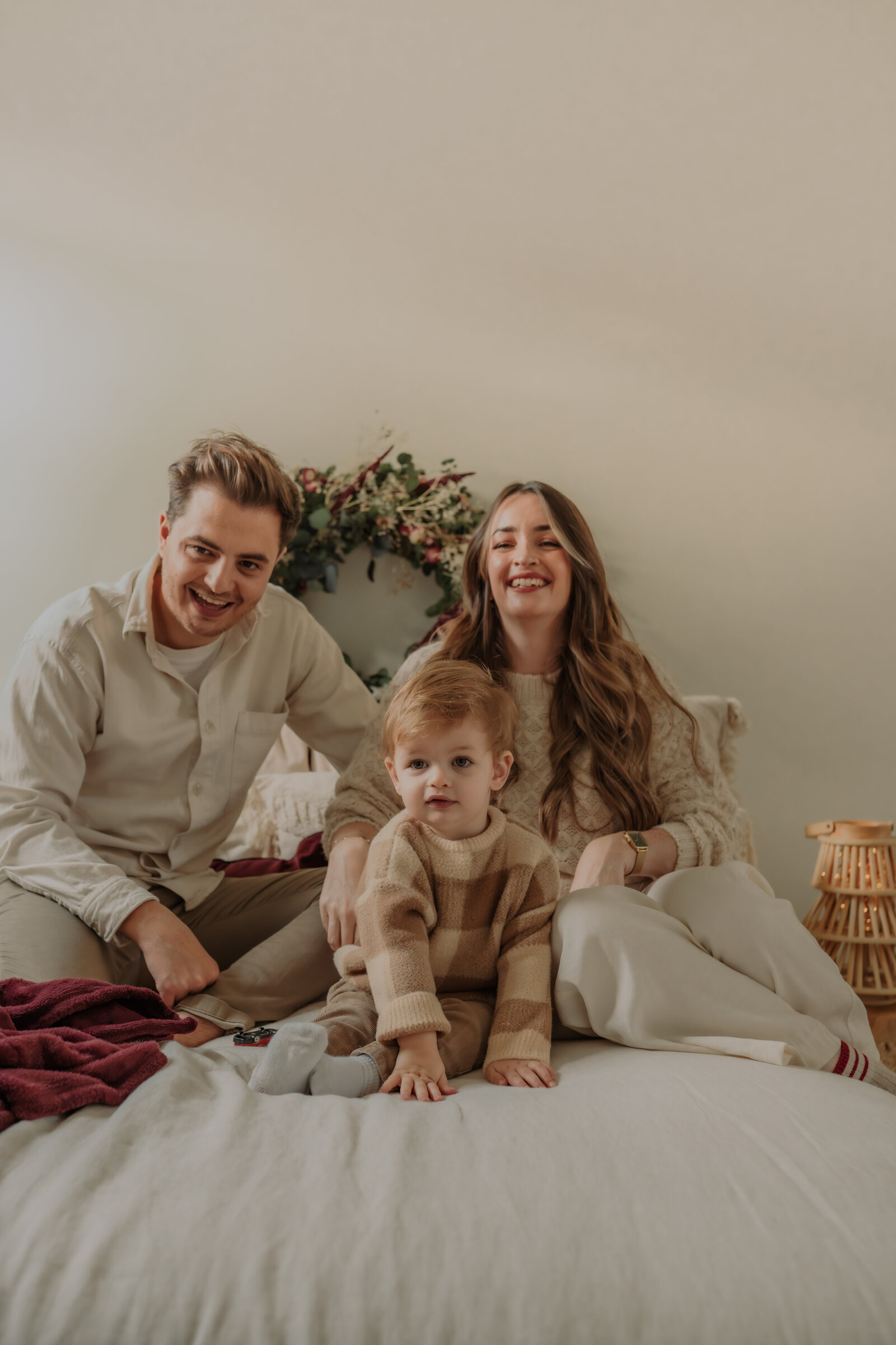 Moeder, vader en zoontje poseert voor familie kerstshoot in daglichtstudio te Antwerpen