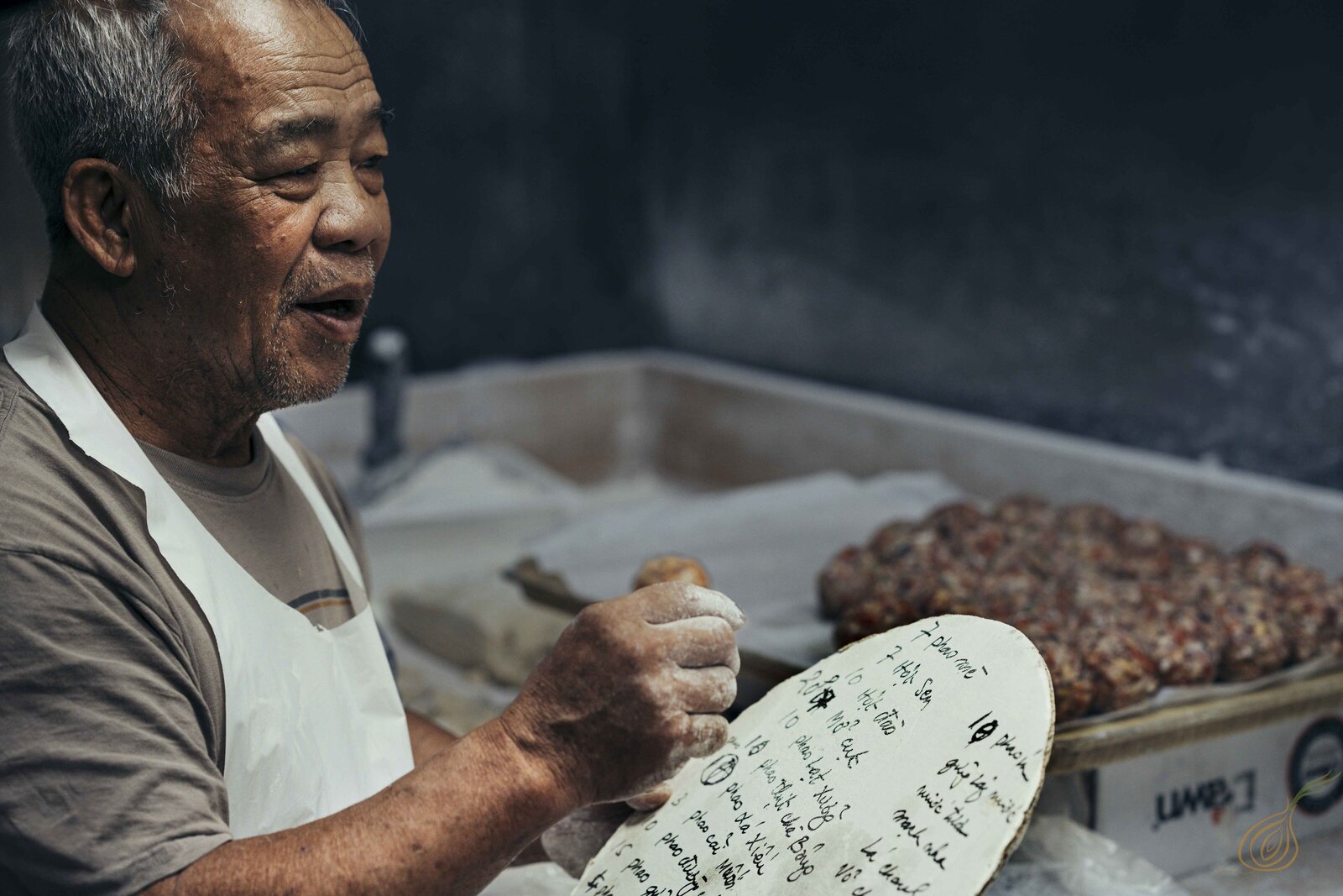 An elderly man is seen making moon cakes in a kitchen, demonstrating his expertise and love for traditional cooking.